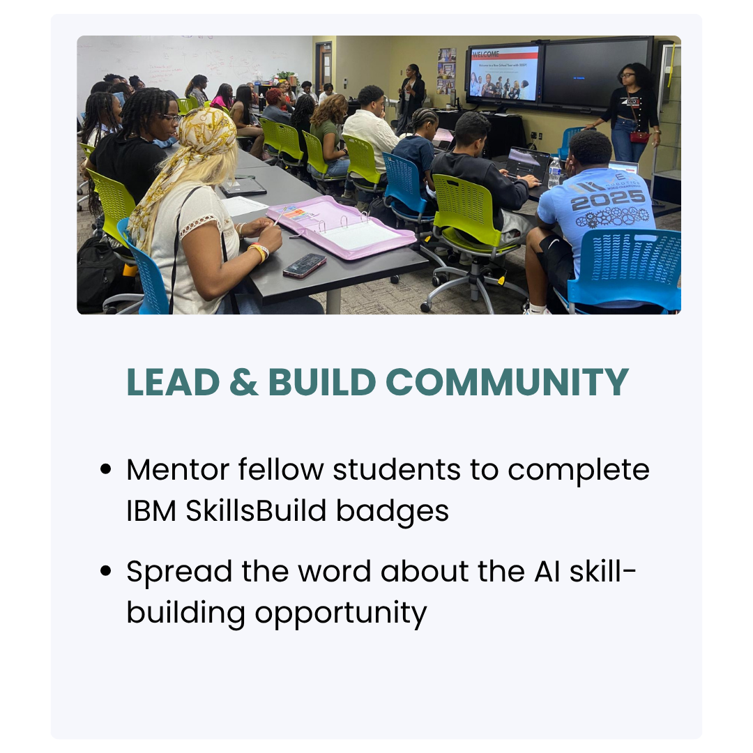 A classroom with students sitting at desks, listening to a woman standing at the front near two large screens. The presentation slide on the screen shows a message about leading and building community, mentoring students, and spreading the word about AI skill-building opportunities.