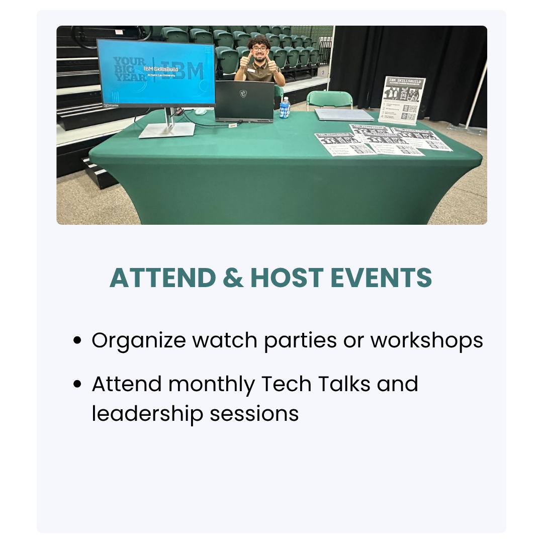 A person at an information table for attending and hosting events, with a monitor, pamphlets, and a sign, in an auditorium setting.