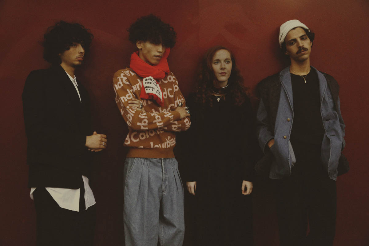 Louis wears jacket and pants HENRIK VIBSKOV shirt ETUDES STUDIO vest HED MAYNER ring MODEL'S OWN . Yannis wears sweater TIGER OF SWEDEN pants 69 scarf BERNHARD WILLHELM . Ruby wears dress STYLIST'S OWN choker ZANA BAYNE necklace MODEL'S OWN . Nassim wears jacket 69 pants and vest STYLIST'S OWN hat and necklace MODEL'S OWN