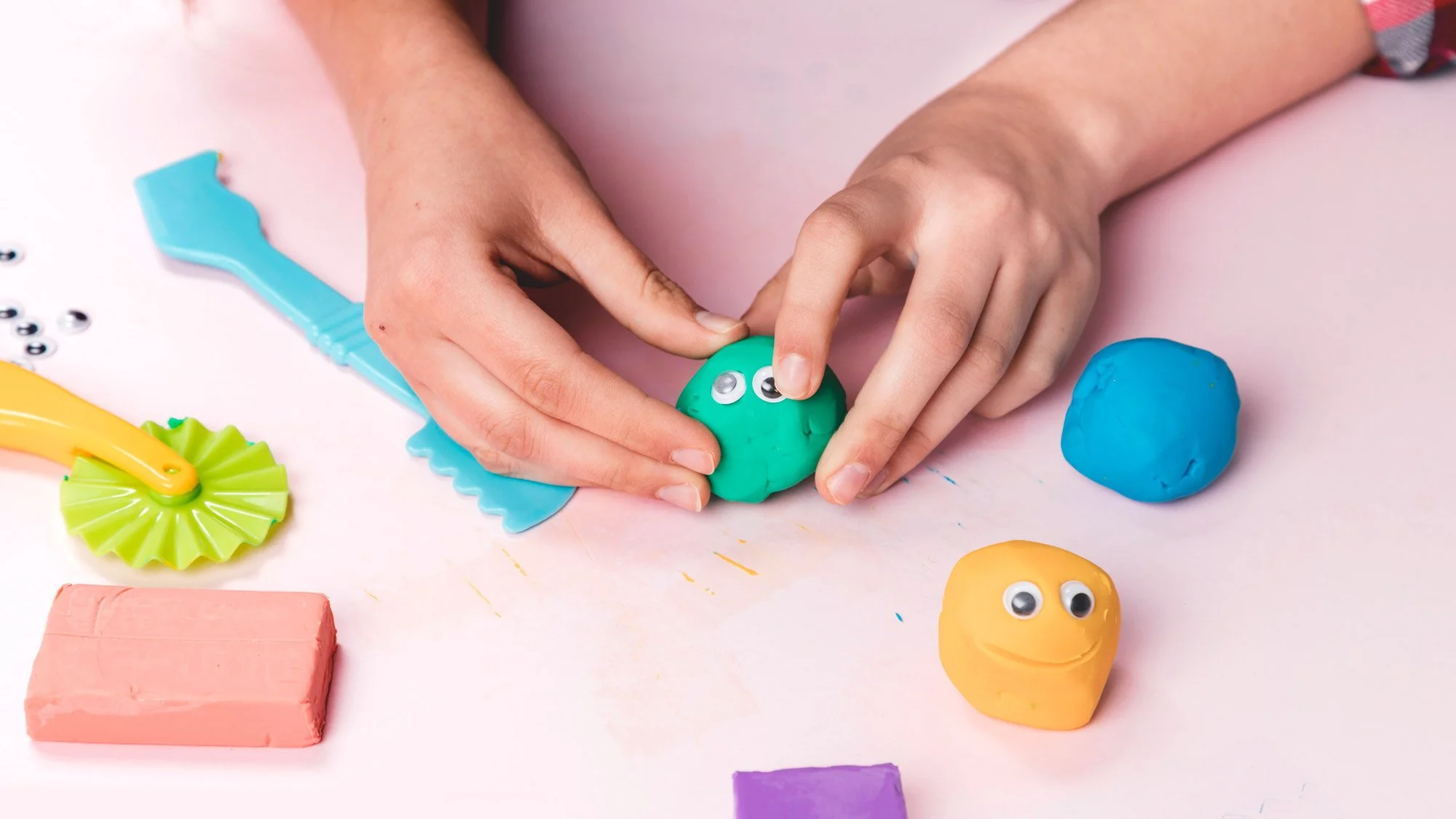 female-artist-hand-making-cartoon-faces-using-soft-clay.jpg