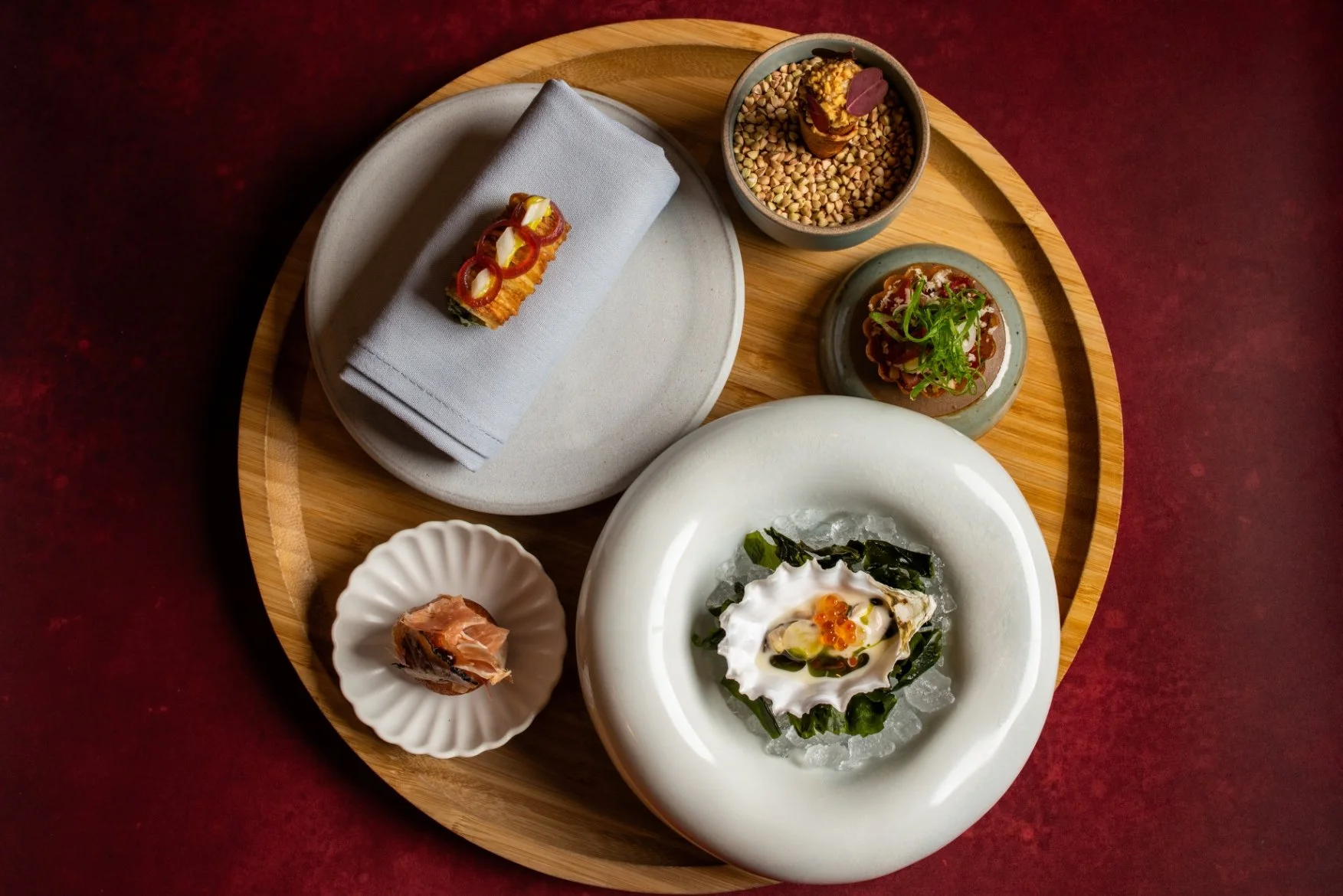 A showcase of amuse bouches (small bites) on varying platewarr available at Sepia Chicago's West Loop tasting menu.