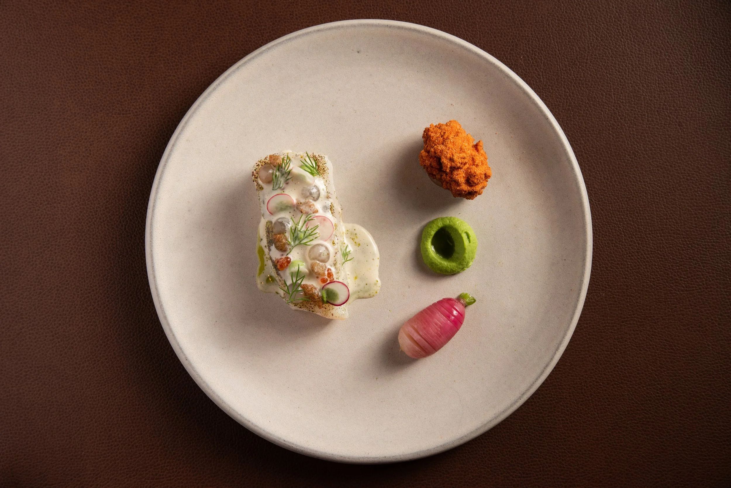 halibut with seasonal vegetables, on a white plate, served during Sepia Chicago's tasting and prix fixe menu