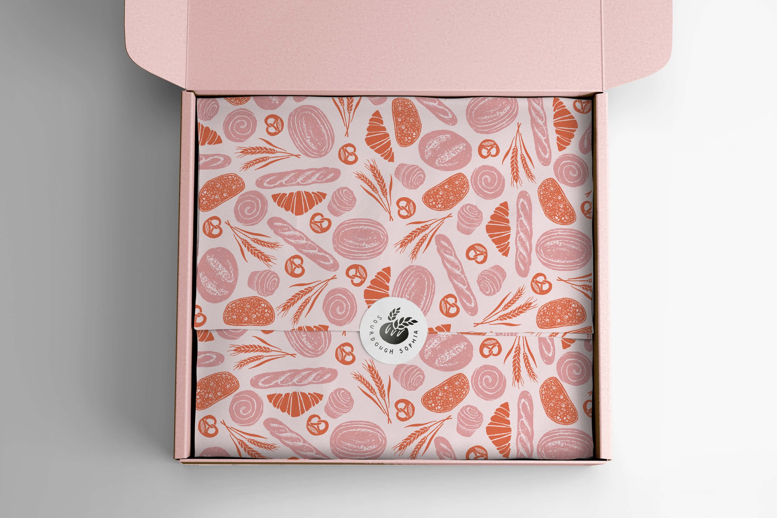  Box with tissue paper design with an illustrative pattern illustration of breads and bakes..The pattern is for a range of packaging for a bakery in pinks and orange with a hand drawn and textured feel. 