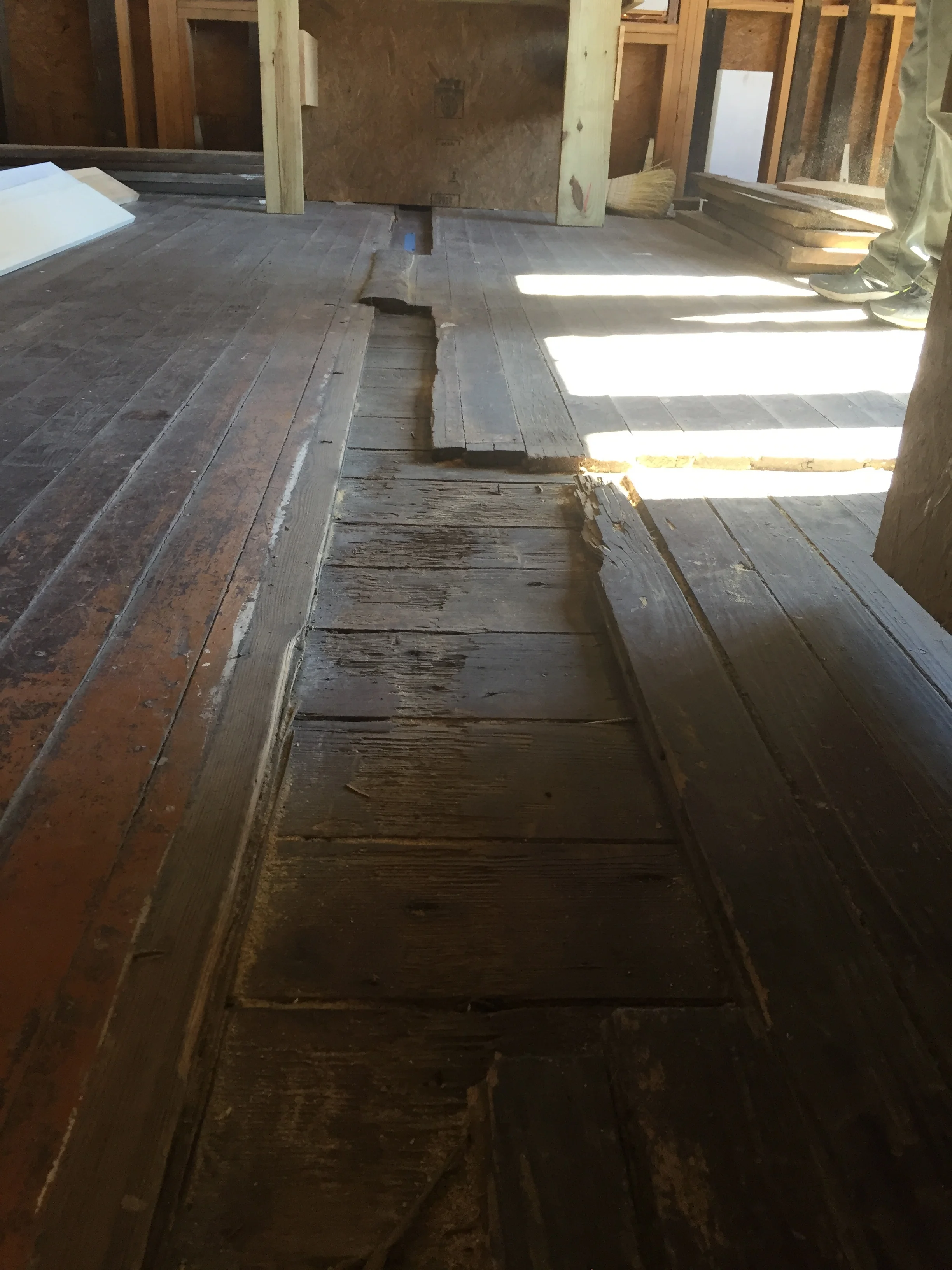 Ghost marks left in the wood floor by a wall and doorway that used to divide the room.