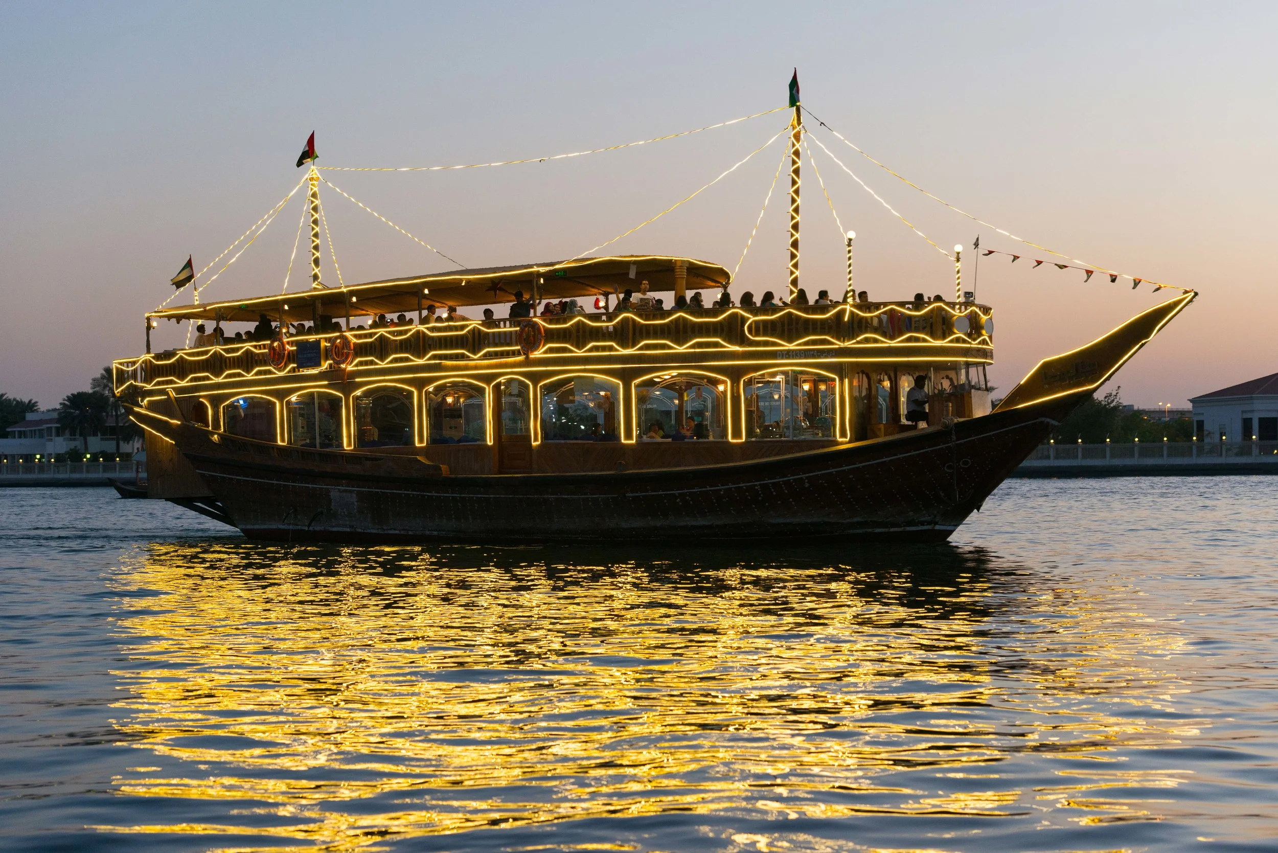 A dhow dinner cruise boat on Dubai Creek at sunset