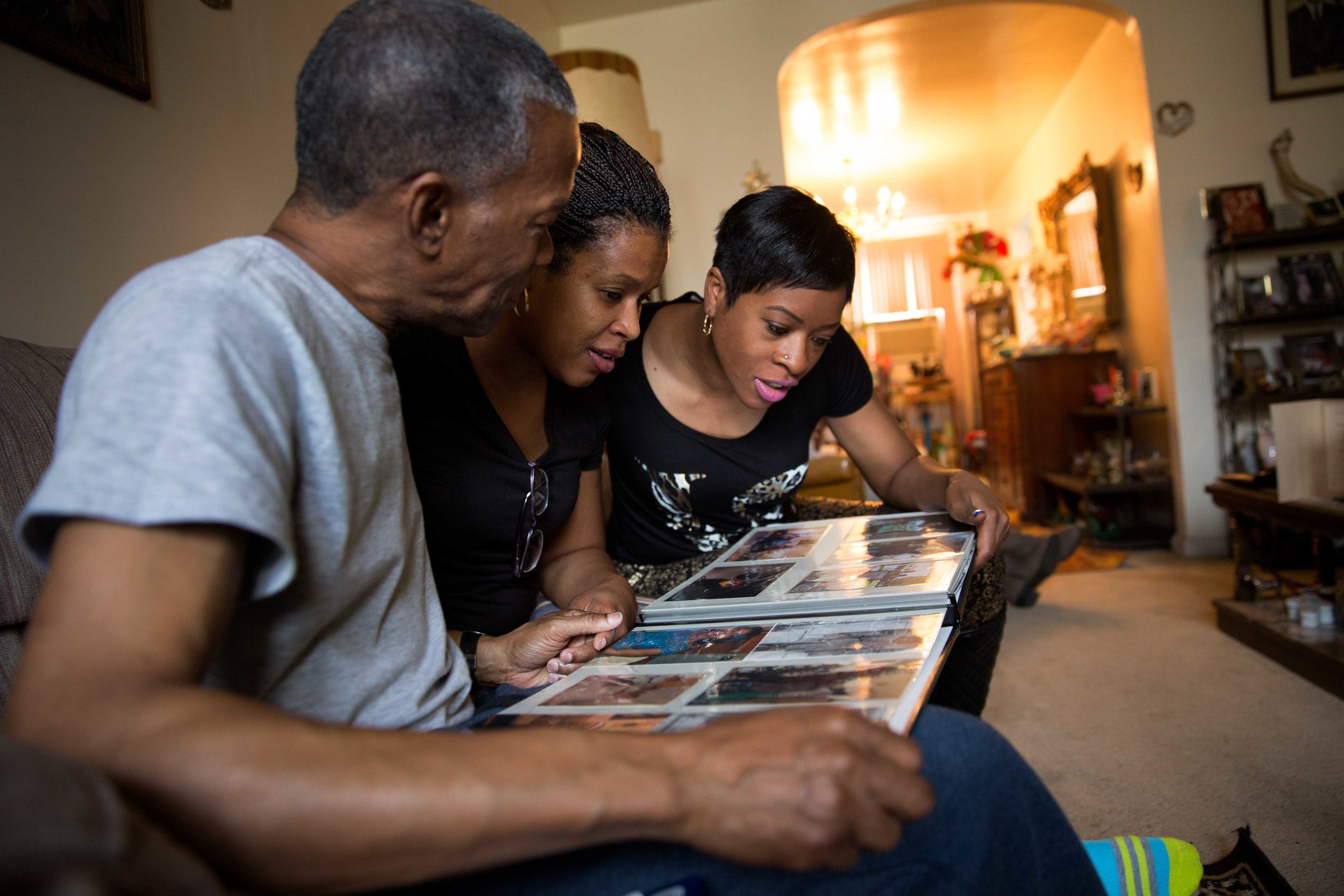 Ronald and his nieces look at a family album at Millie Mae's house.