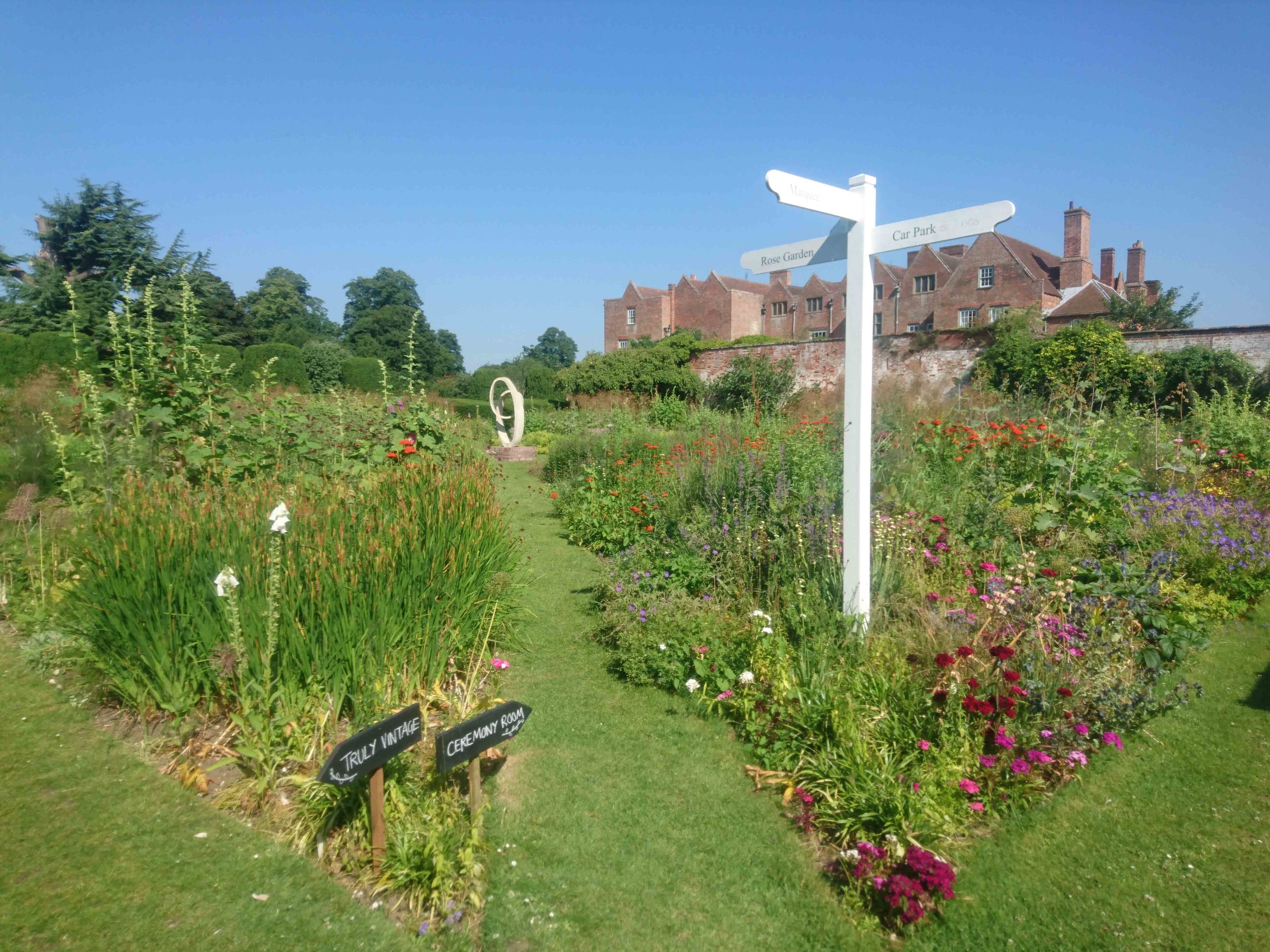 Blue skies and pretty cottage-style planting in the grounds of Glemham Hall! 