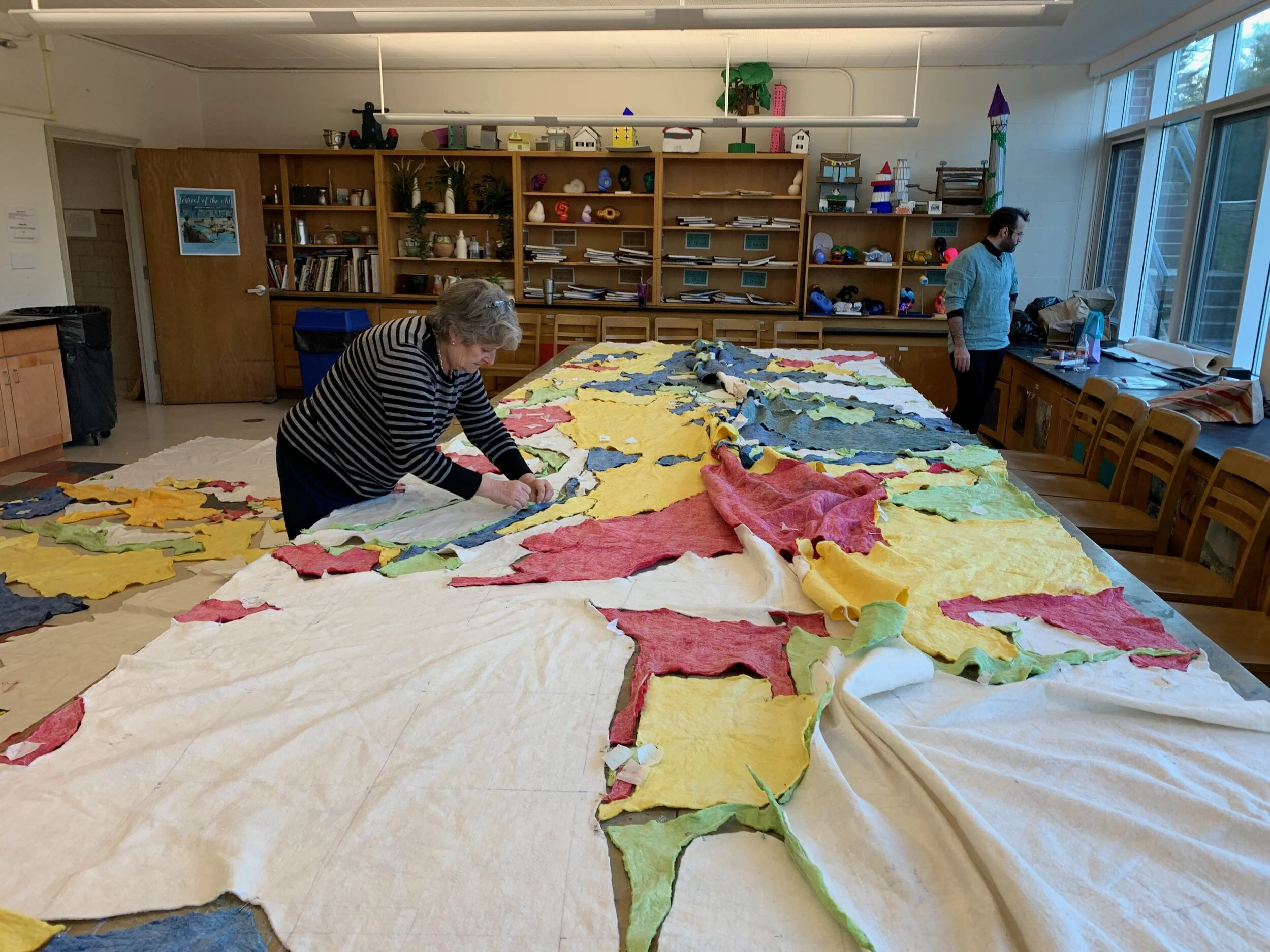 Caroline Rufo’s colleagues Lydia Cutter and Matt Kedzerski assist in piecing together the cotton batting map-quilt.