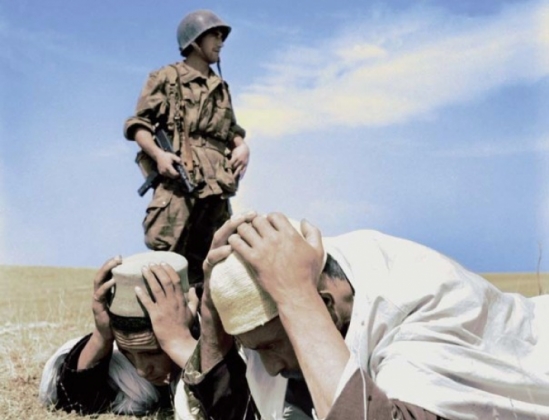 A French soldier arrests two Algerians during the war of 1954-1962