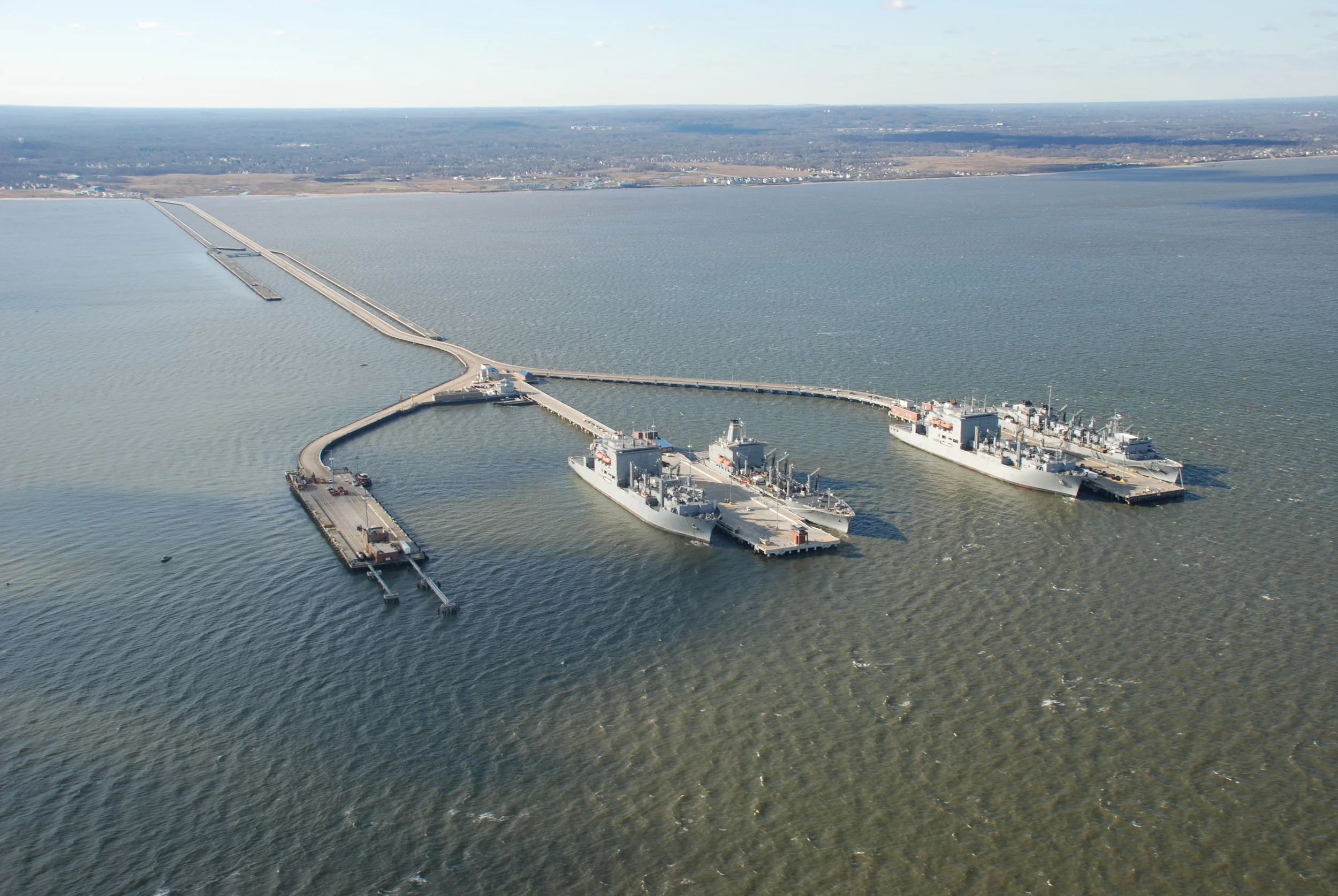  NWS Earle’s Waterfront pier complex extends 2.5 miles into Raritan Bay and is recognized as the line of demarcation between Raritan Bay and Sandy Hook Bay. Comprised of a two-mile trestle which connects to three piers, it is one of the longest finger piers in the world. Photo by Jeffrey C. Doepp, Courtesy of US Navy. 