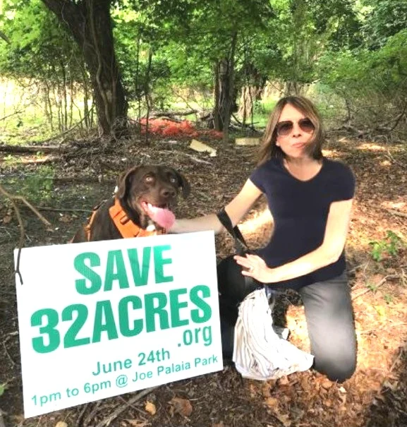 Jacqui with the Save 32 Acre lawn signs that have been posted around the area to raise awareness.
