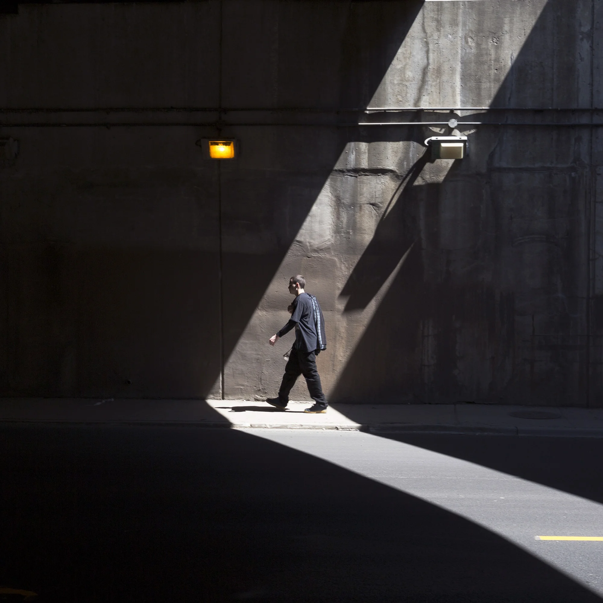 A man walk pass a strip of light at Chinatown Chicago April 17th, 2016.