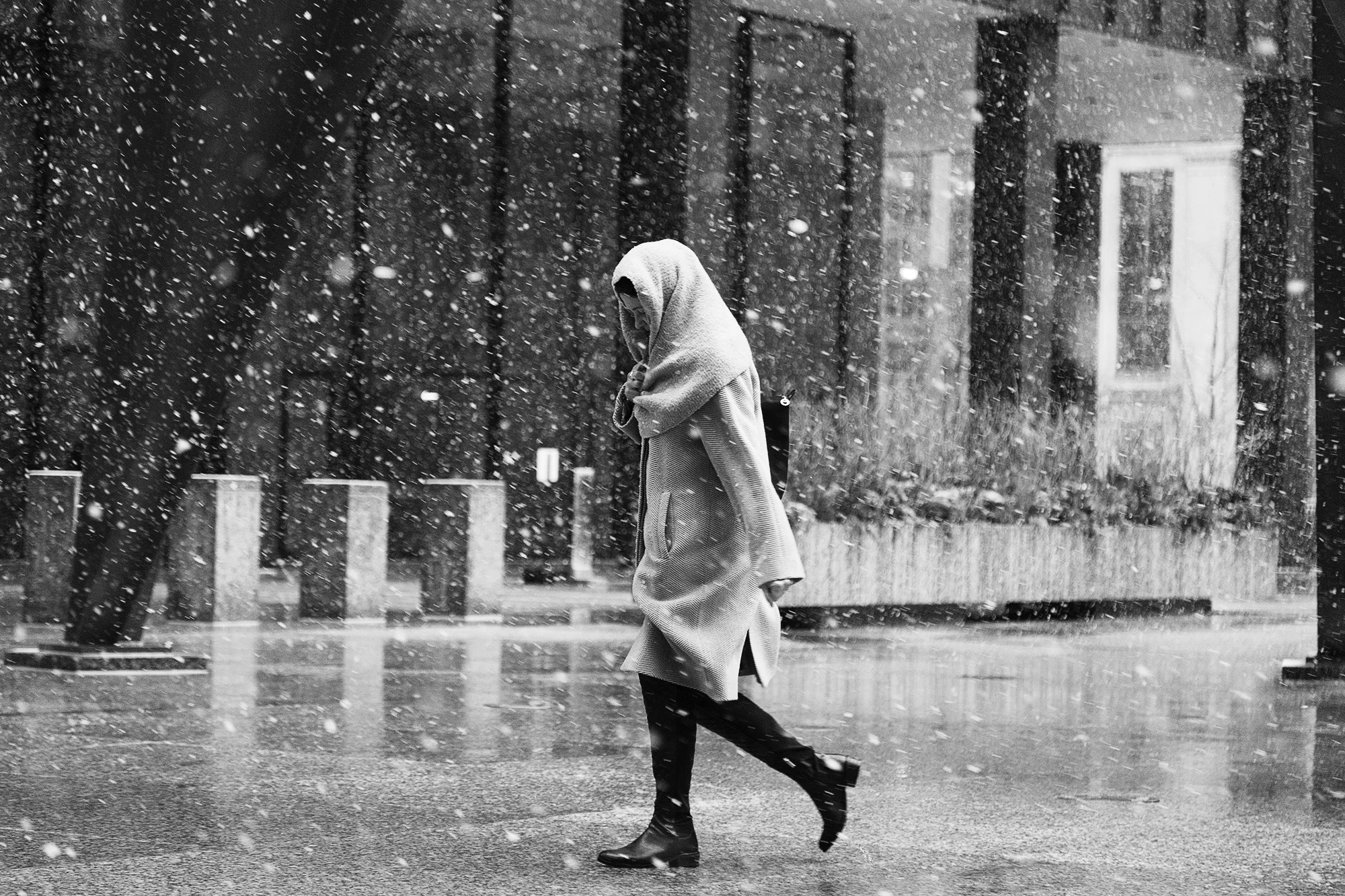 A women covers herself with a scarf while walking pass Chicago's Federal Center on a snowy day, Feb 24, 2016.