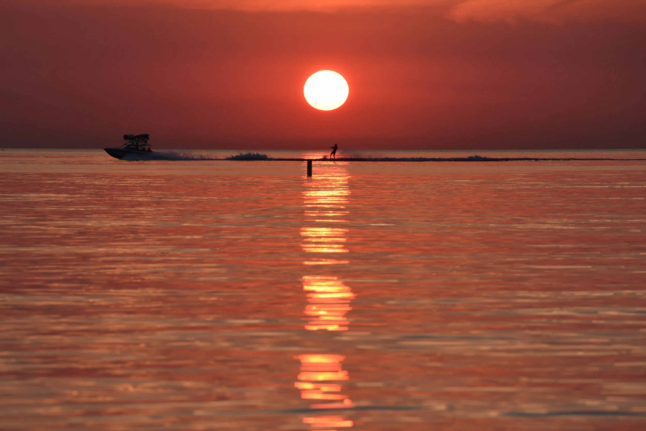 A boat pulls a waterskier through the reflection of the rising sun on Lake Michigan, Tuesday, Aug. 1, 2017 in Chicago. (AP Photo/G-Jun Yam)
