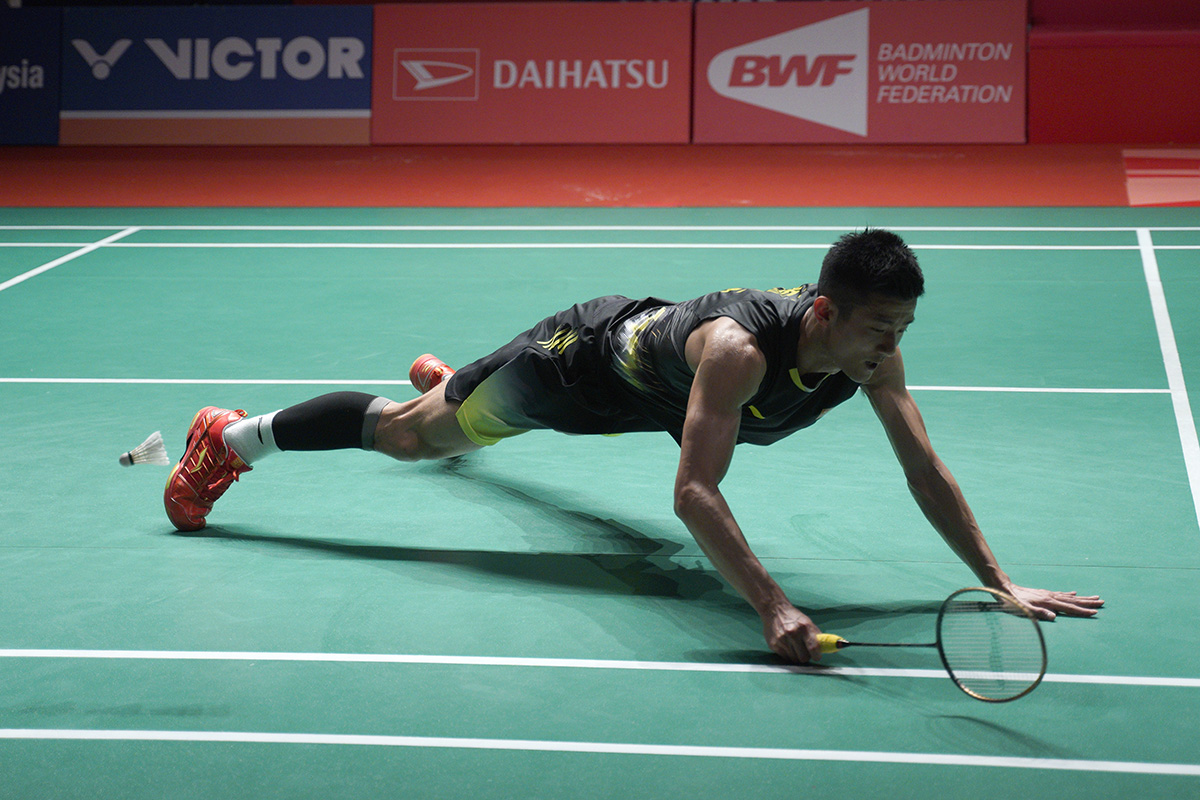 Chen Long of China falls after missing a shot from Viktor Axelsen of Denmark during the men's singles semifinal of the Malaysia Masters badminton tournament in Kuala Lumpur, Malaysia, Saturday, Jan. 19, 2019. (AP Photo/Yam G-Jun)