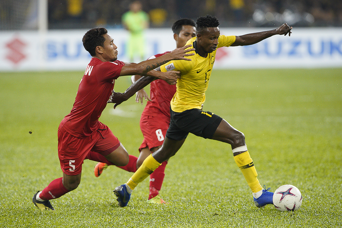 Malaysia's Mohamadou Sumareh, right, battles for the ball with Myanmar Nanda Kyaw and Maung Maung Soe, during the AFF Suzuki Cup at Bukit Jalil National Stadium in Kuala Lumpur, Malaysia, Saturday, Nov. 24, 2018. (AP Photo/Yam G-Jun)