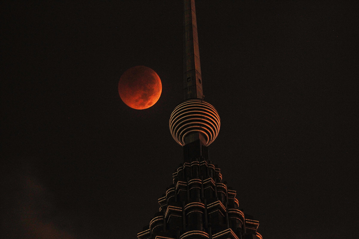 A full moon sets over Petronas Twin Tower during a complete lunar eclipse in Kuala Lumpur, Malaysia, Saturday, July 28, 2018. Skywatchers around much of the world are looking forward to a complete lunar eclipse that will be the longest this century. (AP Photo/Yam G-Jun)