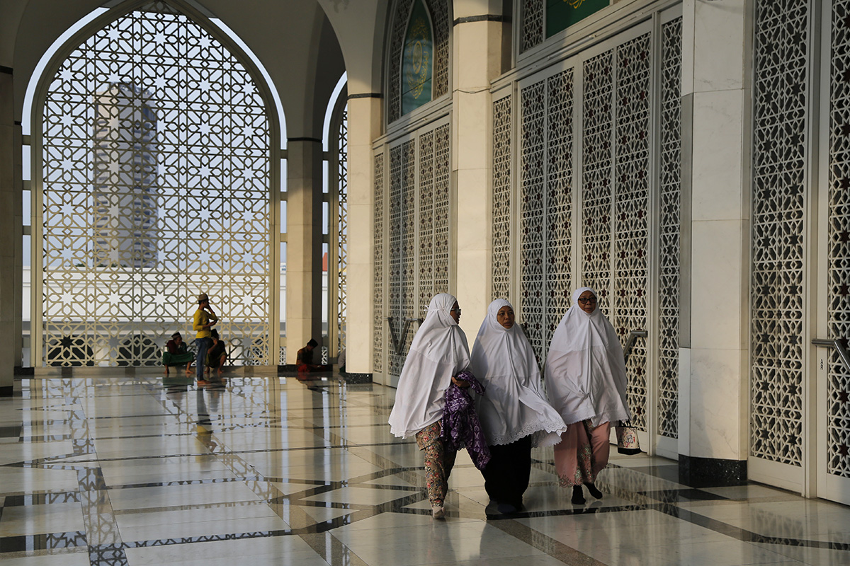 Malaysia Muslim women arrive for prayer during the Islamic holiday of Eid al-Adha at a mosque in Shah Alam, Malaysia, Wednesday, Aug. 22, 2018. (AP Photo/Yam G-Jun)