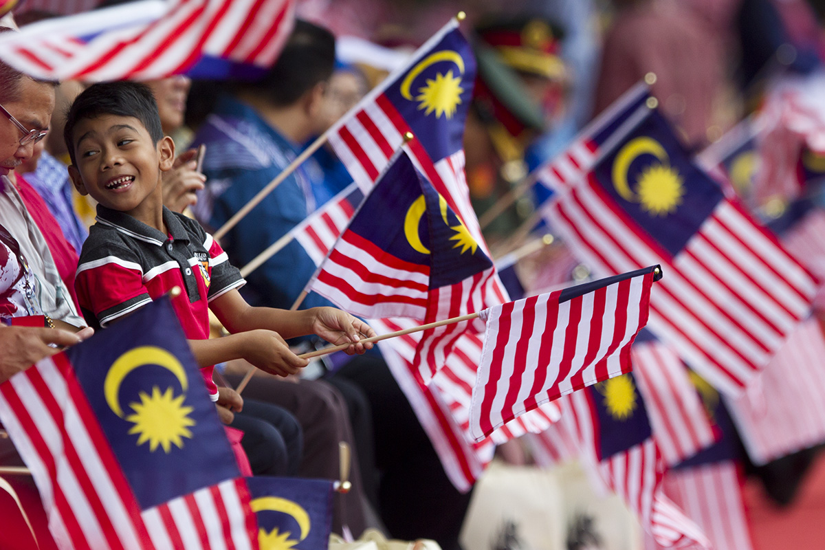 Malaysian waves national flags during the 61st National Day celebrations in Putrajaya, Malaysia, Friday, Aug. 31, 2018. The Federation of Malaya gained its independence from Britain on Aug. 31 in 1957. (AP Photo/Yam G-Jun)