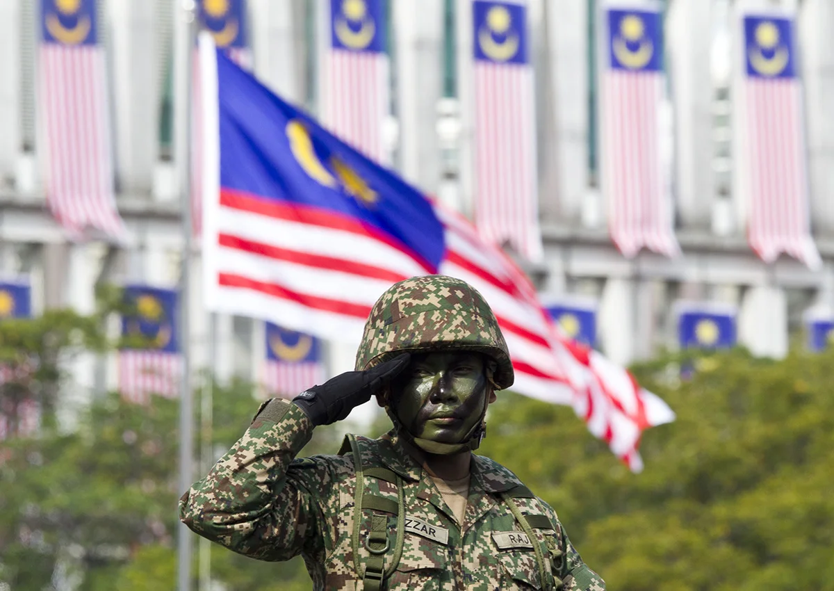 Malaysian military personnel salutes during the 61st National Day celebrations in Putrajaya, Malaysia, Friday, Aug. 31, 2018. The Federation of Malaya gained its independence from Britain on Aug. 31 in 1957. (AP Photo/Yam G-Jun)