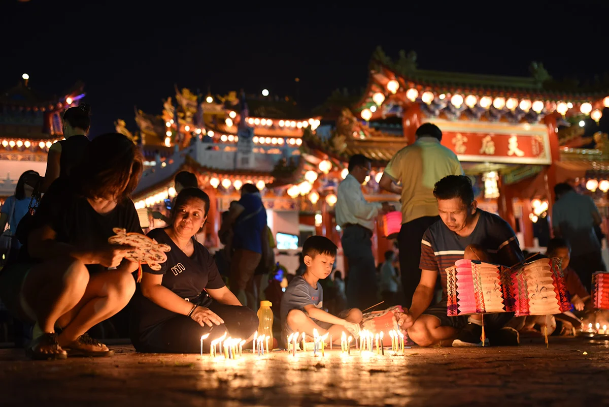Ethnic Chinese people light candles as they celebrate Mid-Autumn Festival at a temple in Kuala Lumpur, Malaysia, Monday, Sept. 24, 2018. (AP Photo/Yam G-Jun)