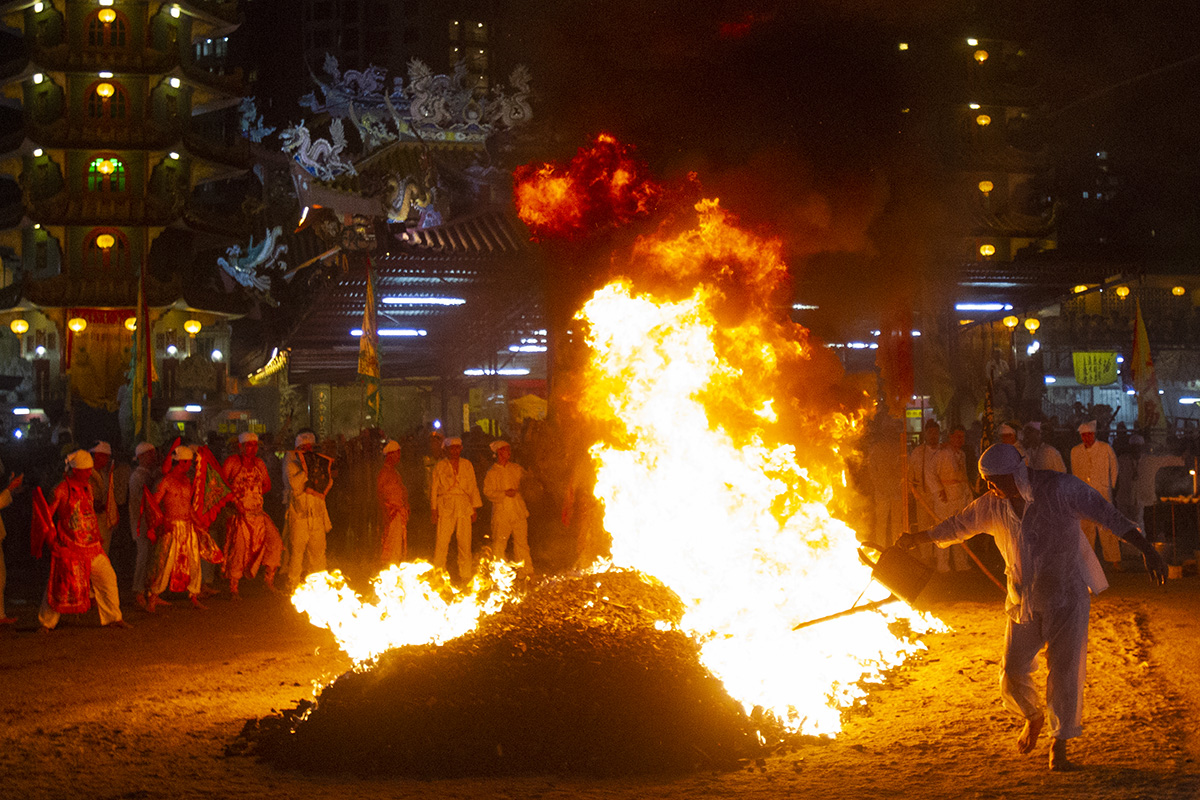 In this Wednesday, Oct. 17, 2018, file photo, A Malaysian ethnic Chinese men prepares the burning coals on the final day of the Nine Emperor Gods Festival at a temple in Ampang, Malaysia. (AP Photo/Yam G-Jun, File)