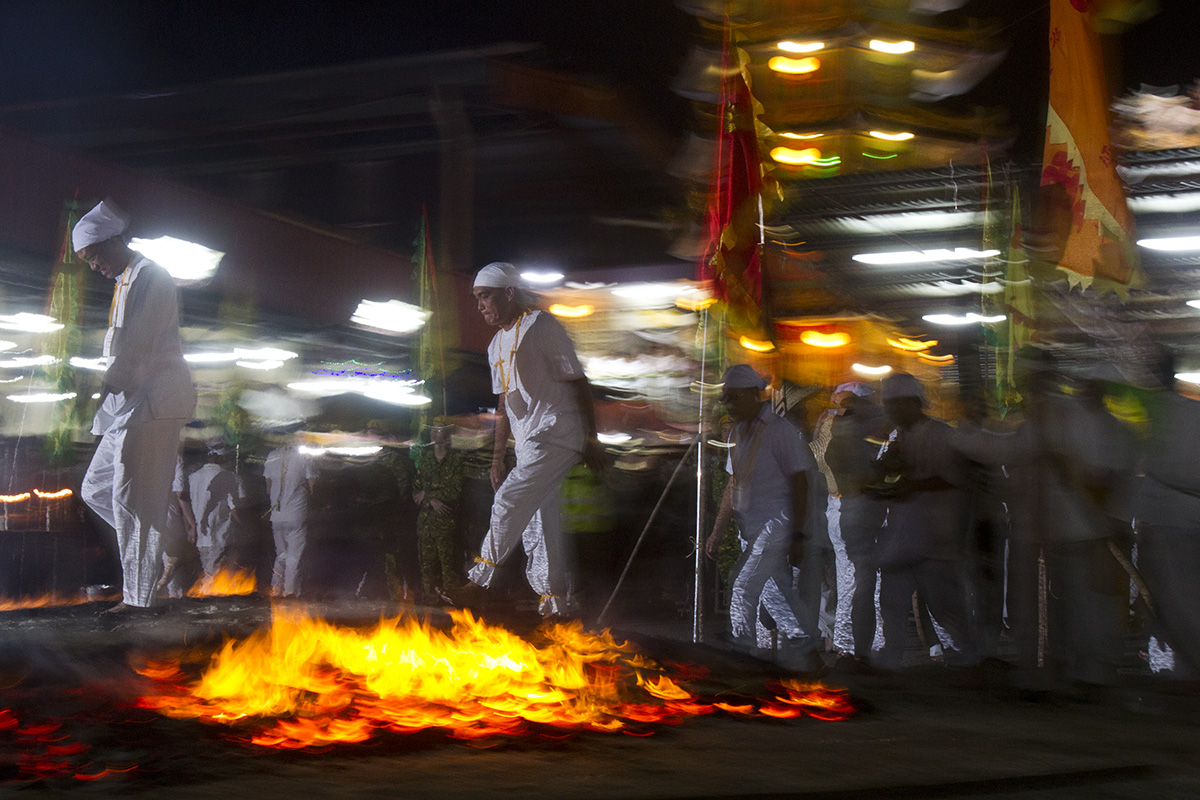 In this Wednesday, Oct. 17, 2018, file photo, Malaysian ethnic Chinese men walk barefoot on a bed of burning coals on the final day of the Nine Emperor Gods Festival at a temple in Ampang, Malaysia. (AP Photo/Yam G-Jun, File)