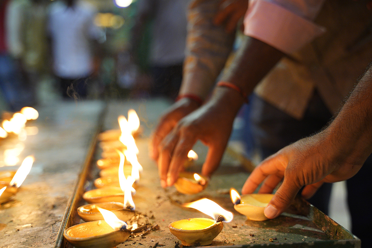 Hindu devotees light clay oil lamps while praying at a temple during the Deepavali celebration in the Batu Caves, Selangor, Malaysia, Tuesday, Nov. 6, 2018. (AP Photo/Yam G-Jun)
