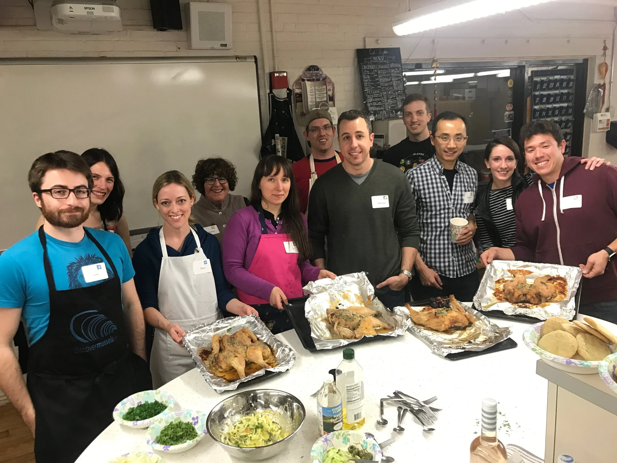 Group of cooking class students serving all the food Jacqueline Church taught them to make. Roast chicken, citrus compound butter, and shaved fennel with vinaigrette.