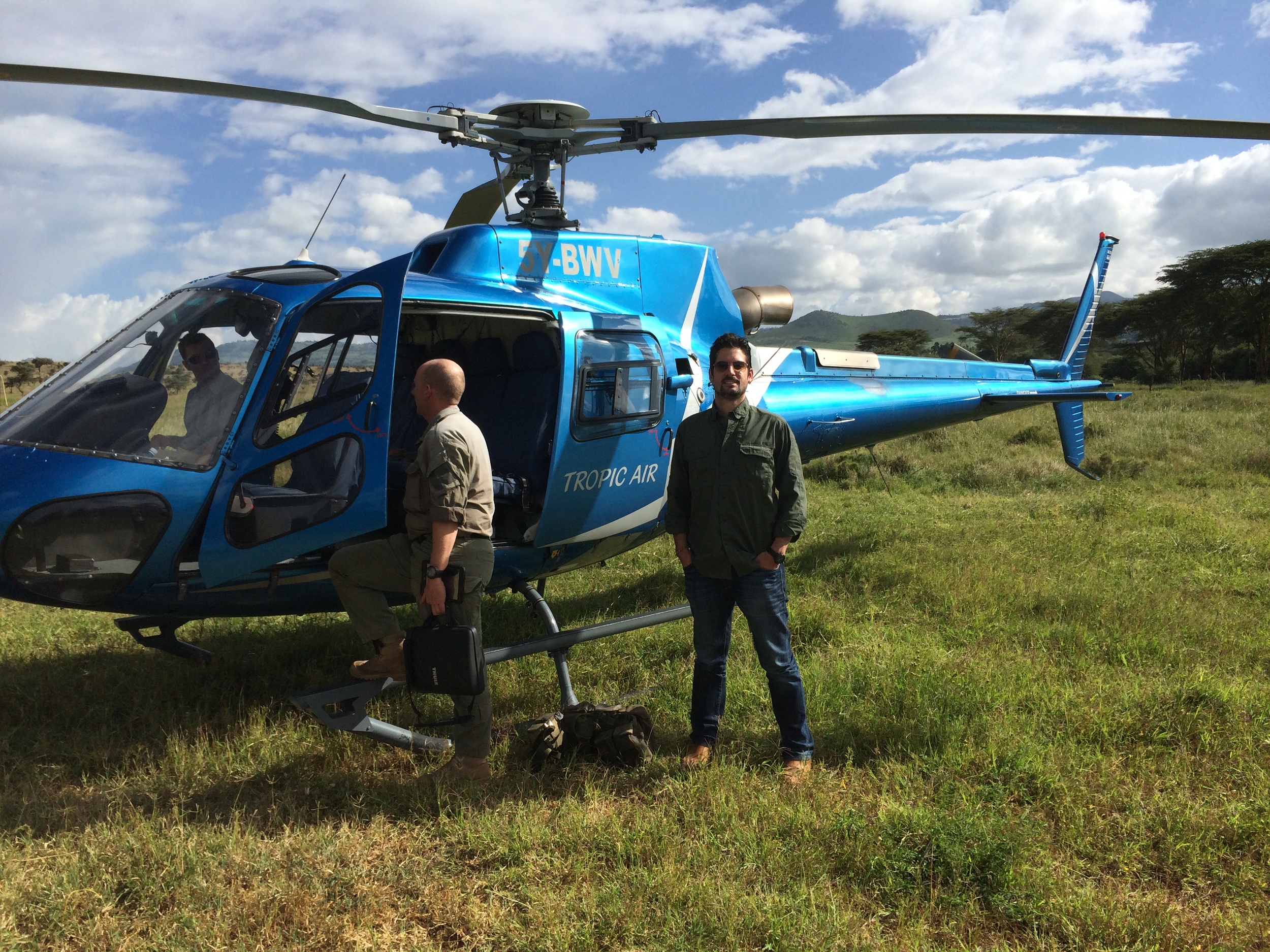 Me next to our helicopter just before flying over Kenya.JPG