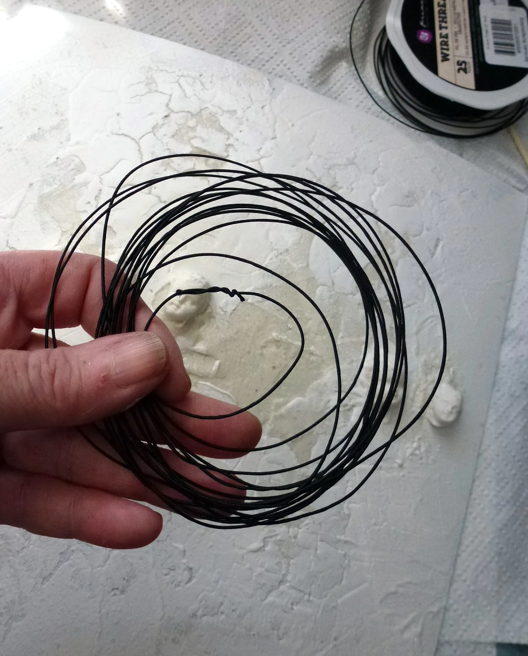 Create a photo frame using wire thread, begin by forming multple loops and then bend into the shape of a heart, attach to back ground using a stapler