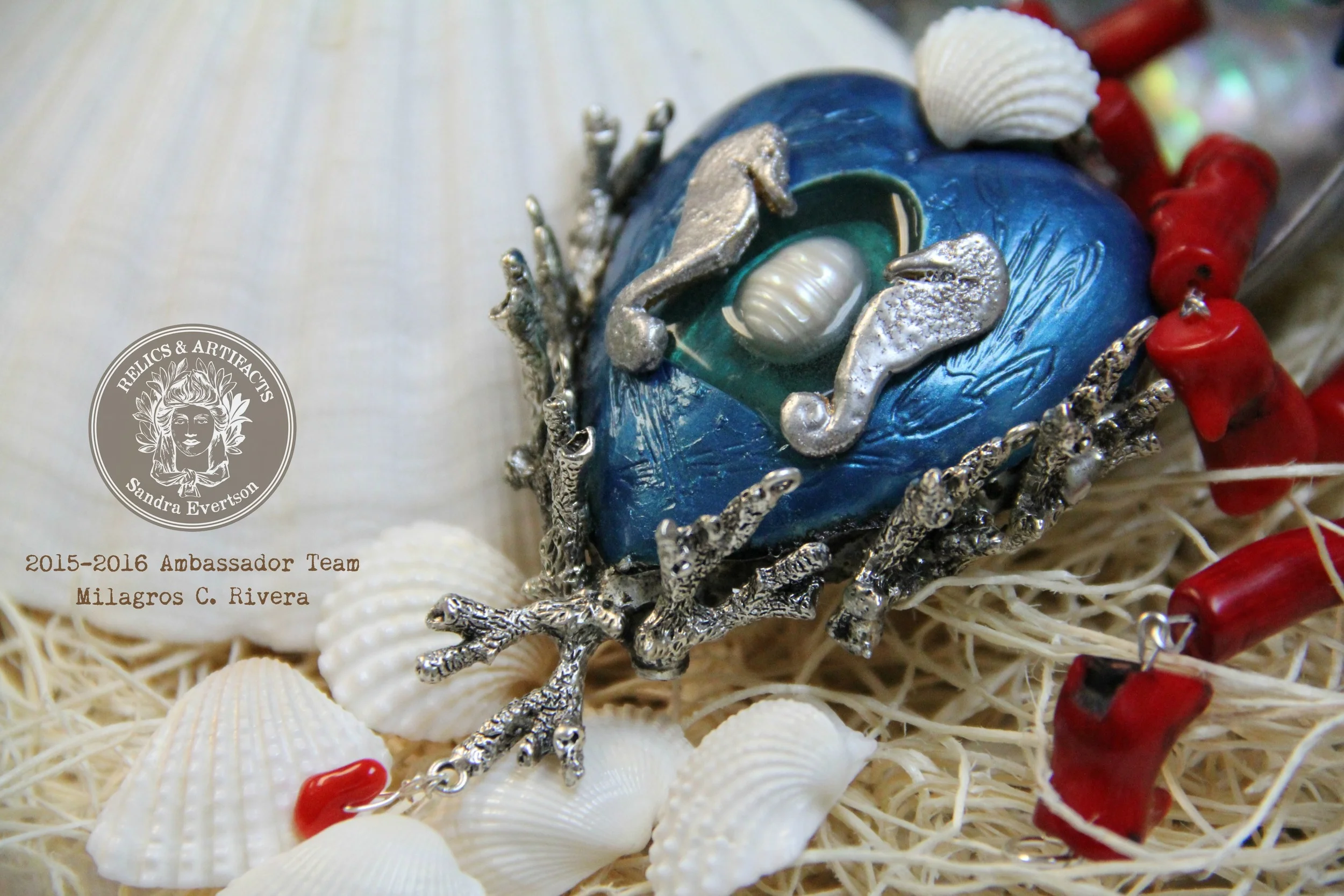 shades of deep turquoise nestle a fresh water pearl, deeper shades of blue surrounds the piece