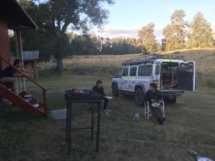 White VU14 XUG at camp near Villarrica, showing rear side glazing and expedition equipment.