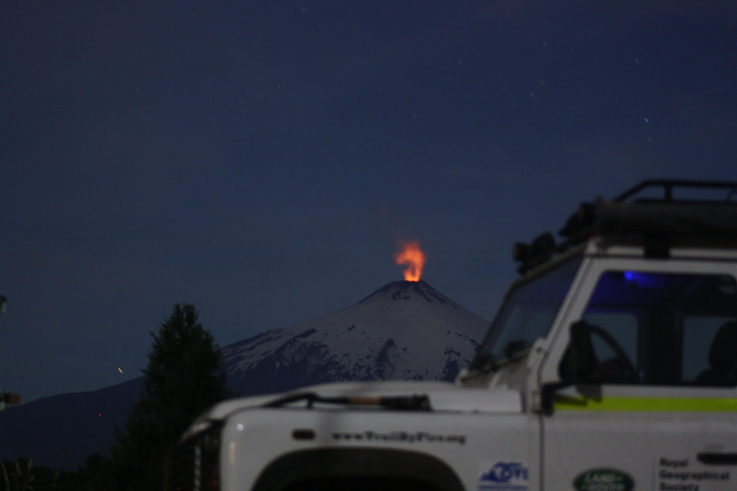 Trail by Fire Defender beside Villarrica at night.