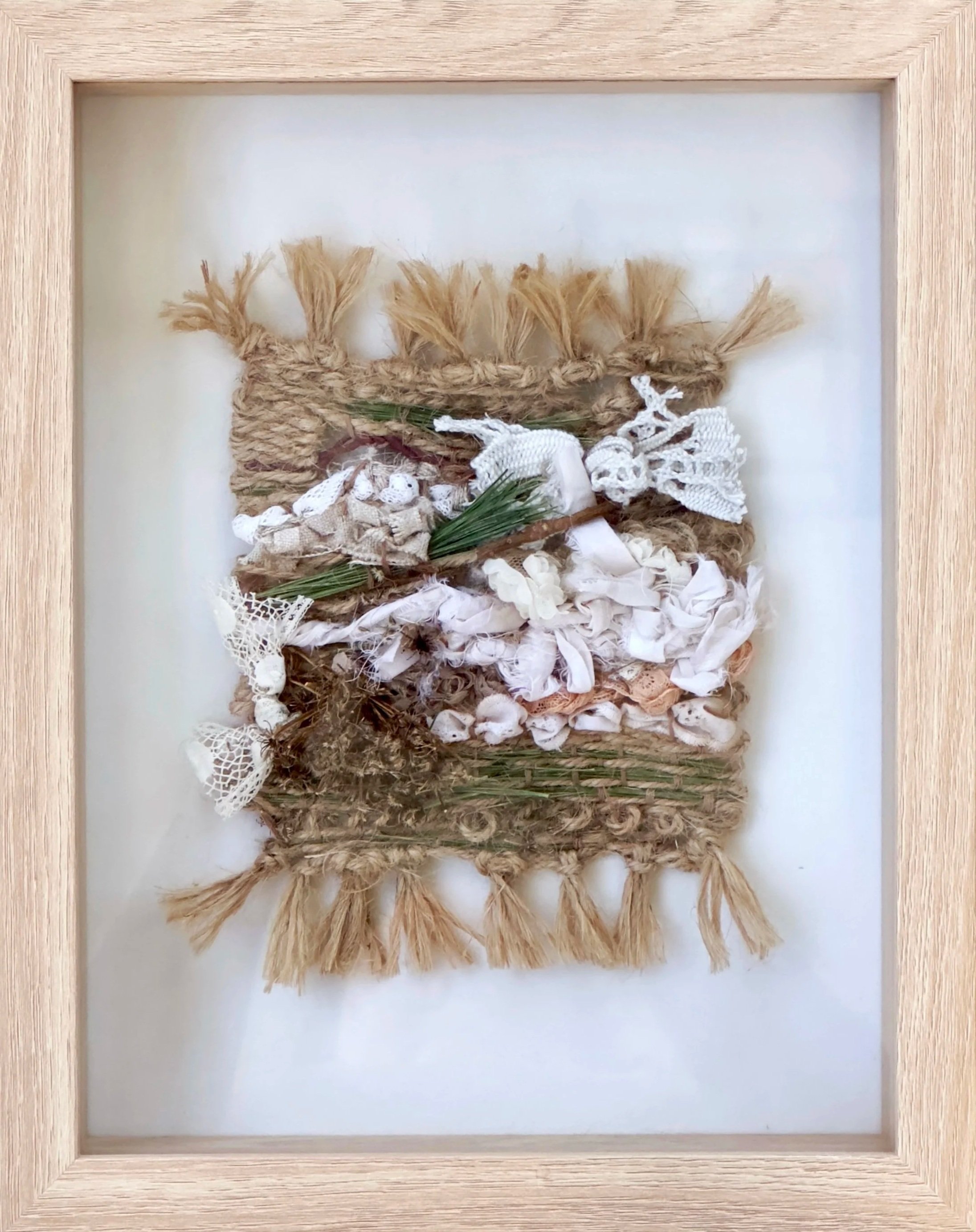    Pine and lace   , 2026 . Twine, plant material, fabric and lace remnants. 11”H x 8.5”W (framed).  Available by inquiry  