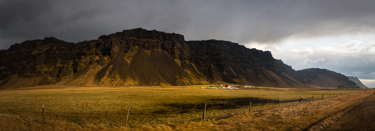 White Farmhouse and Mountain Range in Iceland