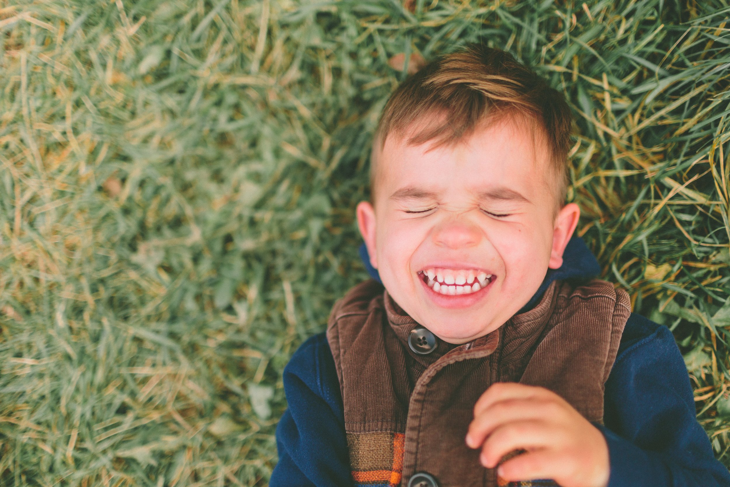 Peaceful Smiles: Boy Relaxing in Grass - Garden City Pediatric Dentistry