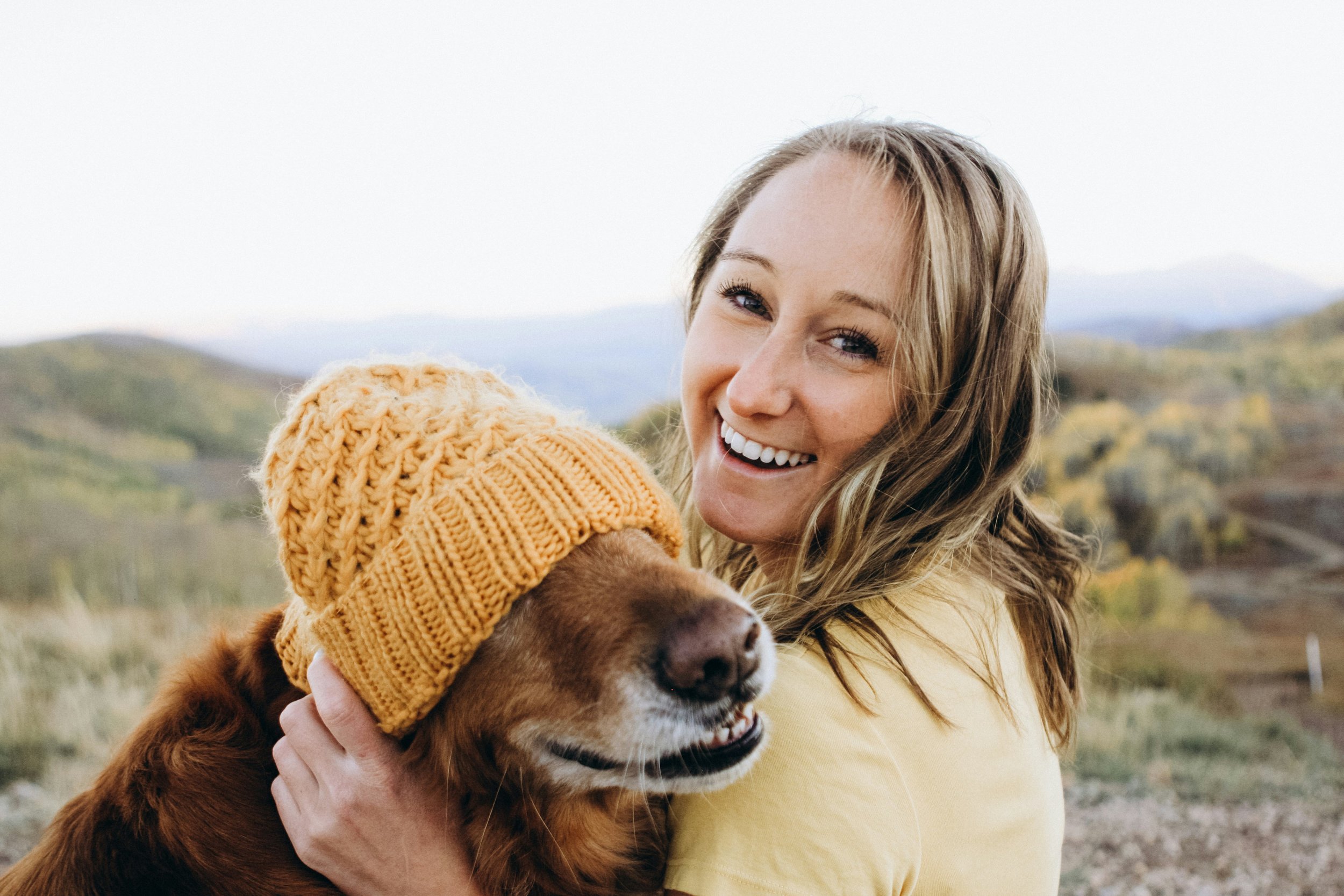 Adventure Smiles: Woman and Dog Enjoying Mountain Views - Garden City Dental Care