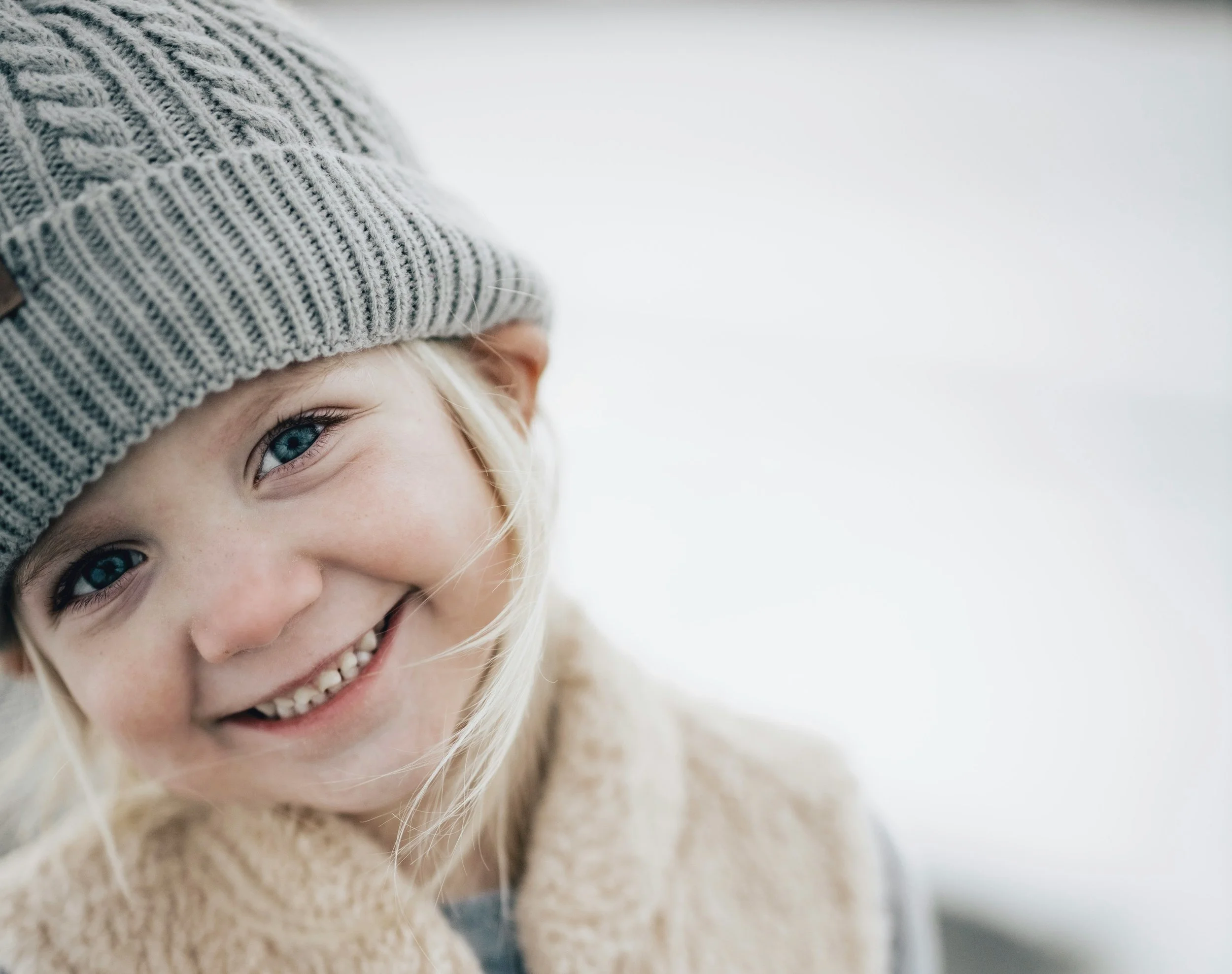 Winter Joy: Smiling Child in Warm Clothes - Garden City Family Dentistry