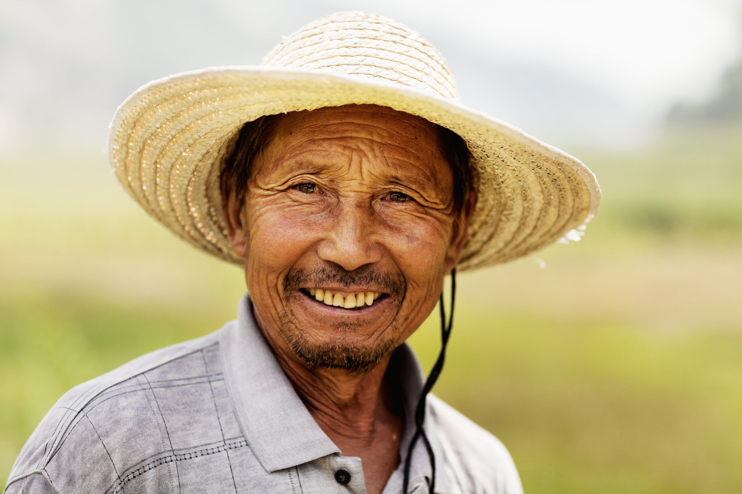 Natural Joy: Close-Up of Ethnic Man Smiling in a Field - Garden City Dental Wellness