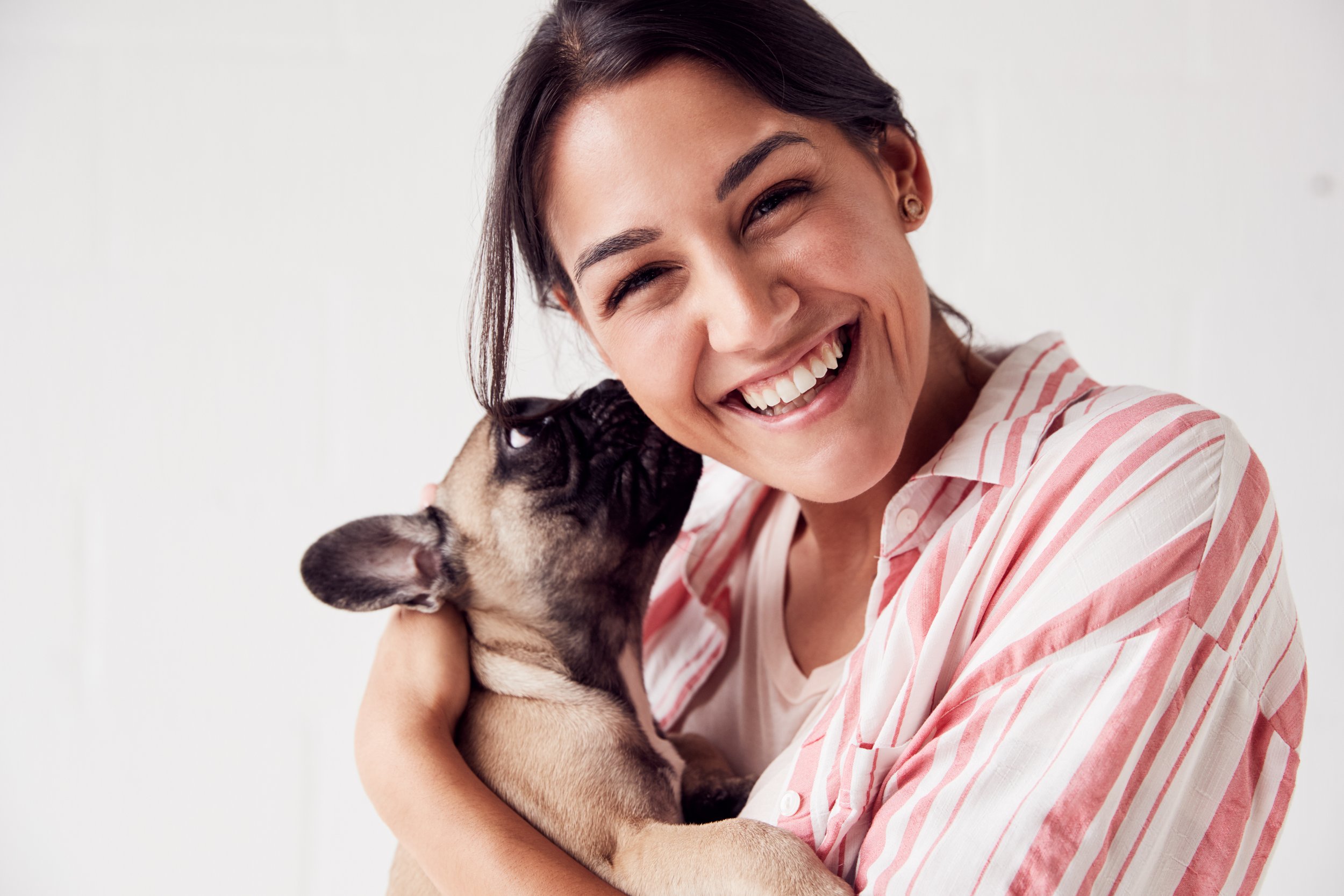 Pure Joy: Smiling Woman & Playful Pug Moments - Garden City Dental Care