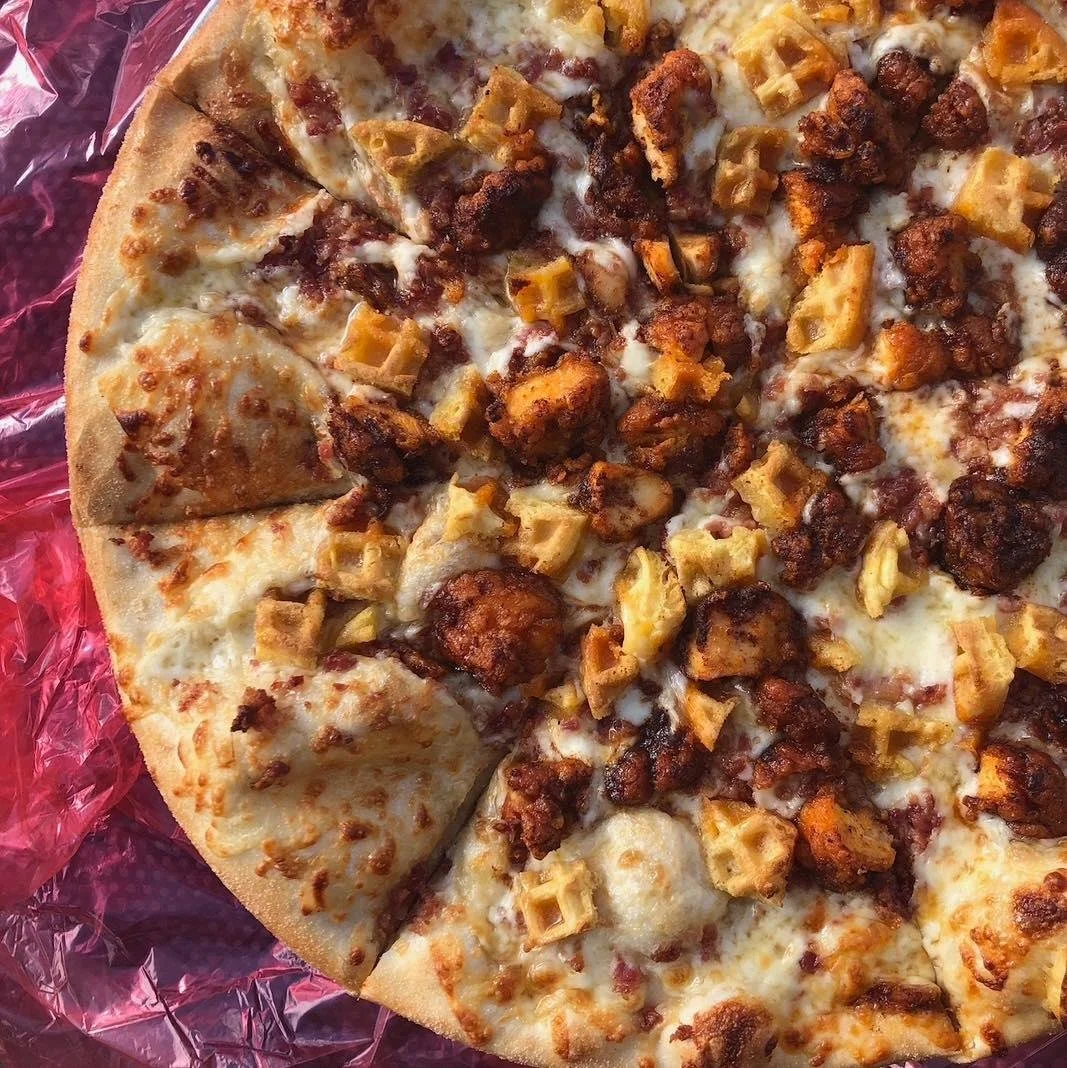 Chicken and Waffles available all of December at Germantown and Deer Park! Mozzarella + waffle bits + Nashville style hot chicken + bacon + syrup drizzle. #chickenandwaffles  #itsgettingsticky #louisvillepizza #pizzaofthemonth