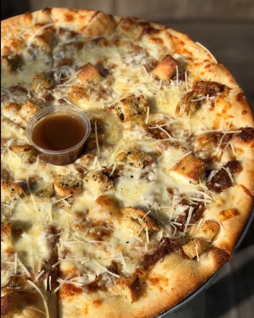 French Onion Pizza is back for the month of February! Caramelized onion + mozzarella + gruyere + croutons + topped with shredded parmesan + served with a jus sauce. Come get cozy with this soup inspired pizza. #louisvillepizza #louisvillefood  #pizza