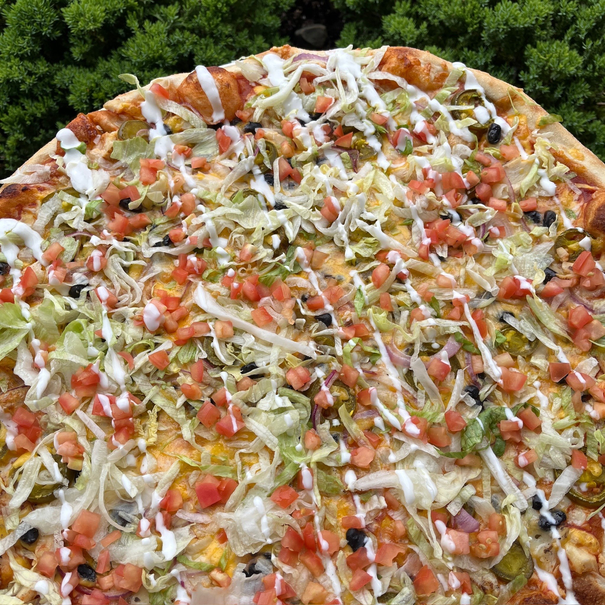 Taco Pizza for the month of May! 
Taco sauce base + mozzarella + cheddar + black beans + fajita chicken + jalapeno + red onion + topped with lettuce + tomato + sour cream drizzle. Available at Germantown and Deer Park.