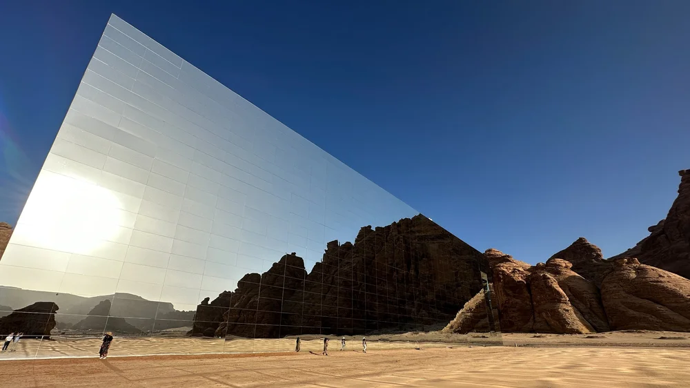 A mirrored building reflecting the AlUla desert