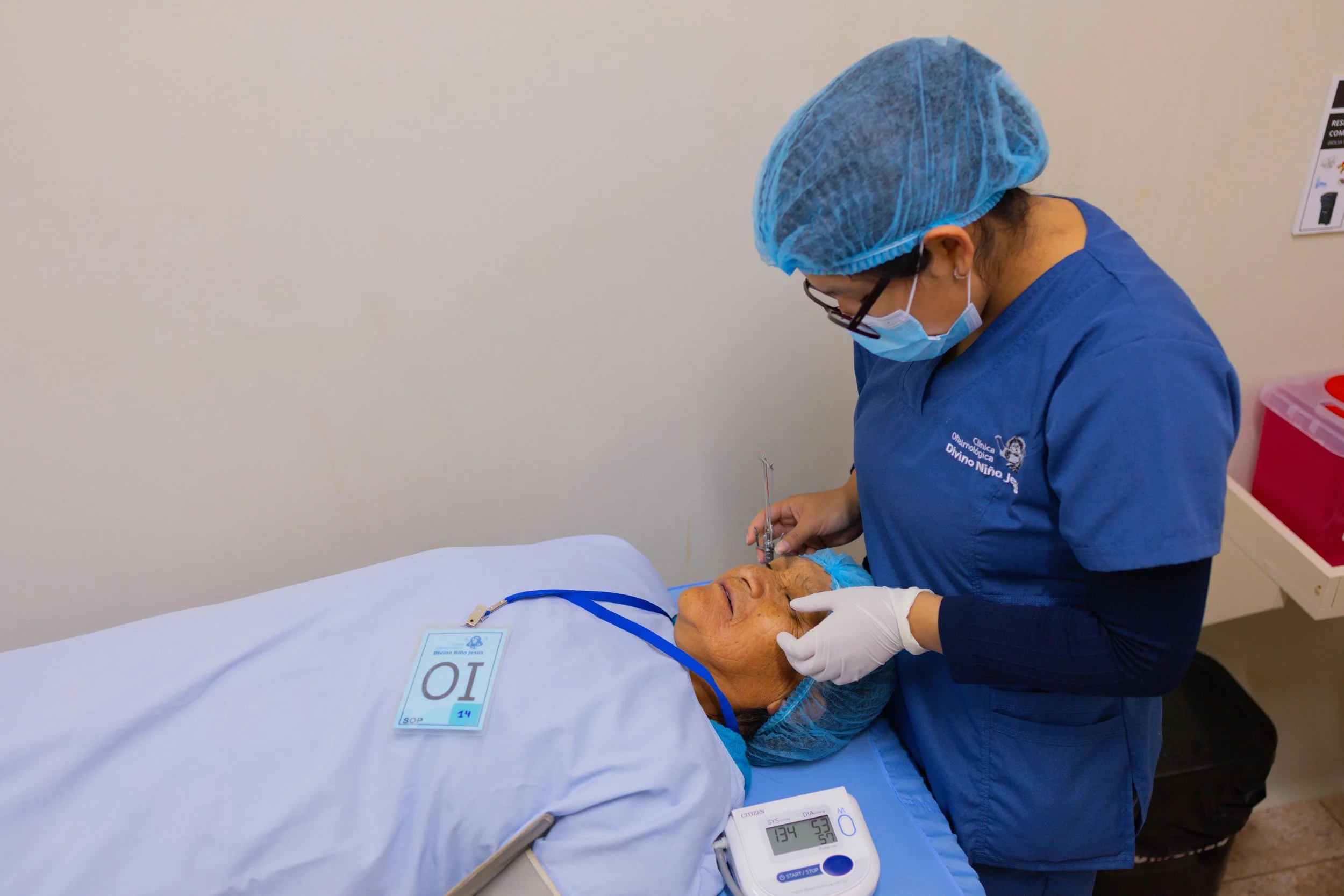 A clinician caring for a woman lying on a hospital bed