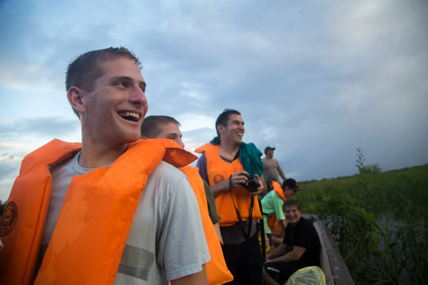 Jesse Axelowitz, Ryan Axelowitz, Jason Stoll, Corey Axelowitz, Nico Frost, and Juan Carlos look over as the people on the second fishing boat catch piranhas in the Amazon River