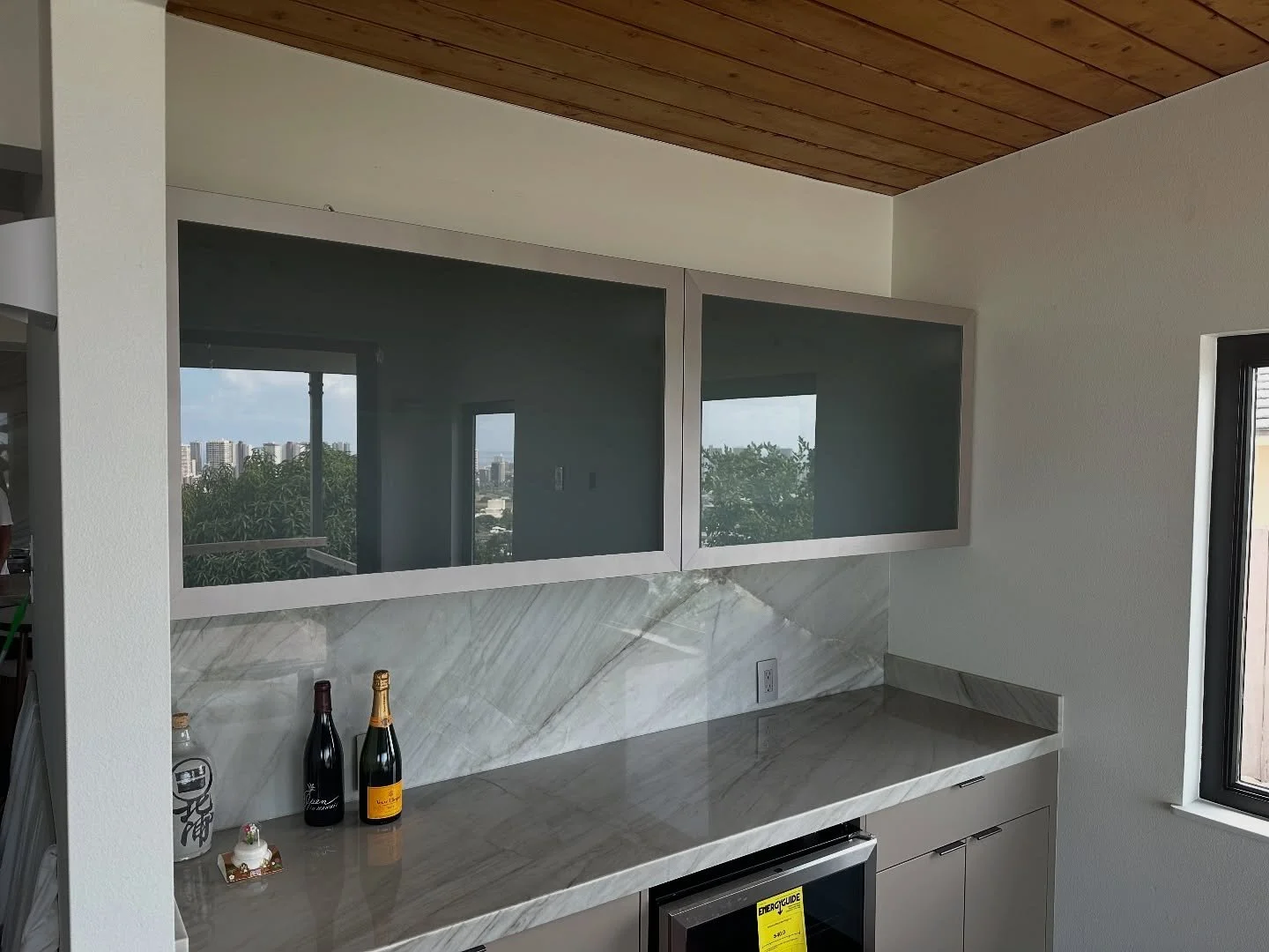 The combination of aluminum-framed glass doors and solid base cabinets creates a visually appealing contrast at this living room bar. 
Cabinets:  IslandModern&reg;️

#barcabinet #customcabinets #glasscabinet #kailuabusiness #customcabinetshop #island