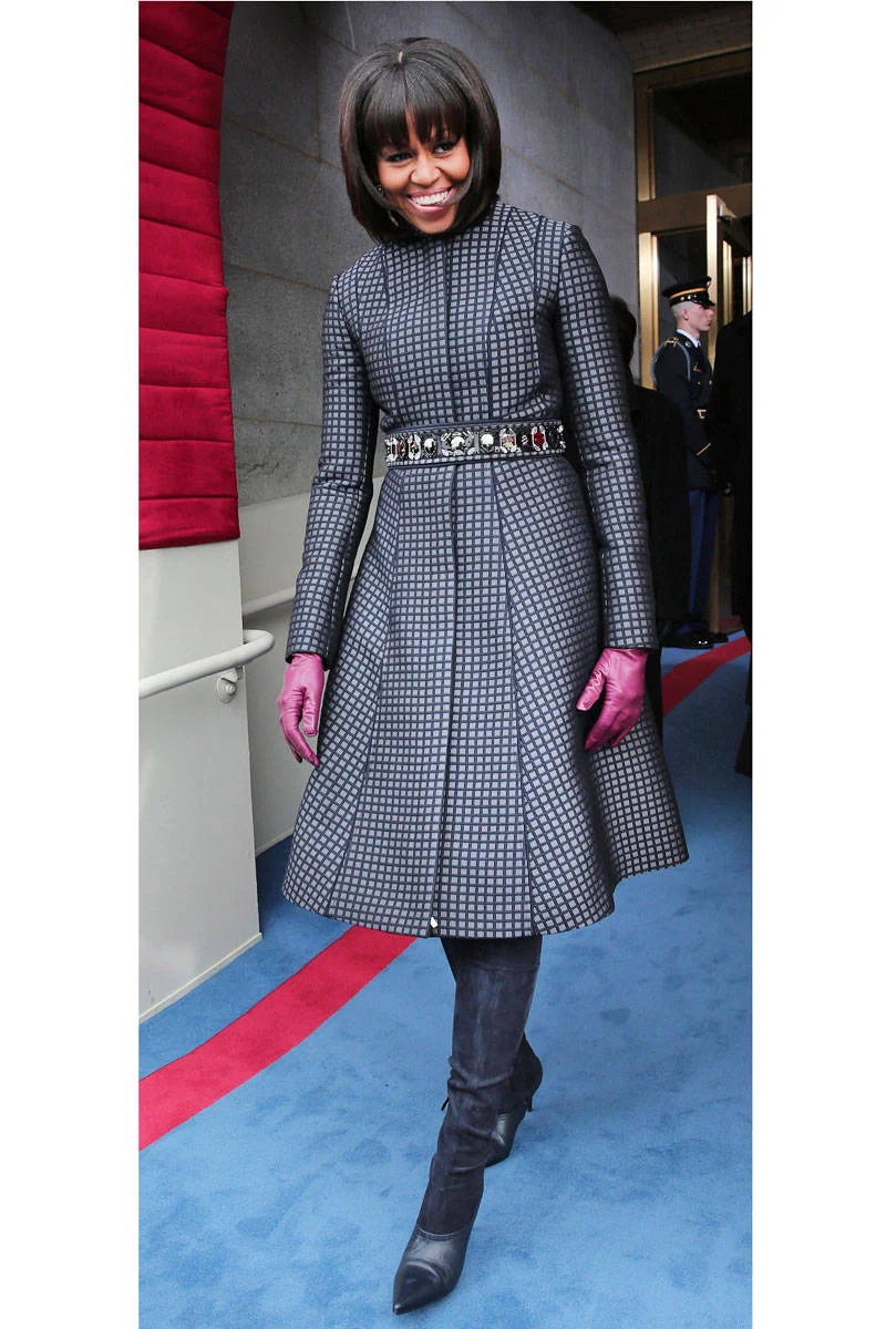 The stylish First Lady preparing to make her way through the Capitol during the Inauguration Parade in a navy and light blue checkered coat by Thom Browne, Reed Krakoff boots, and J.Crew accessories. 