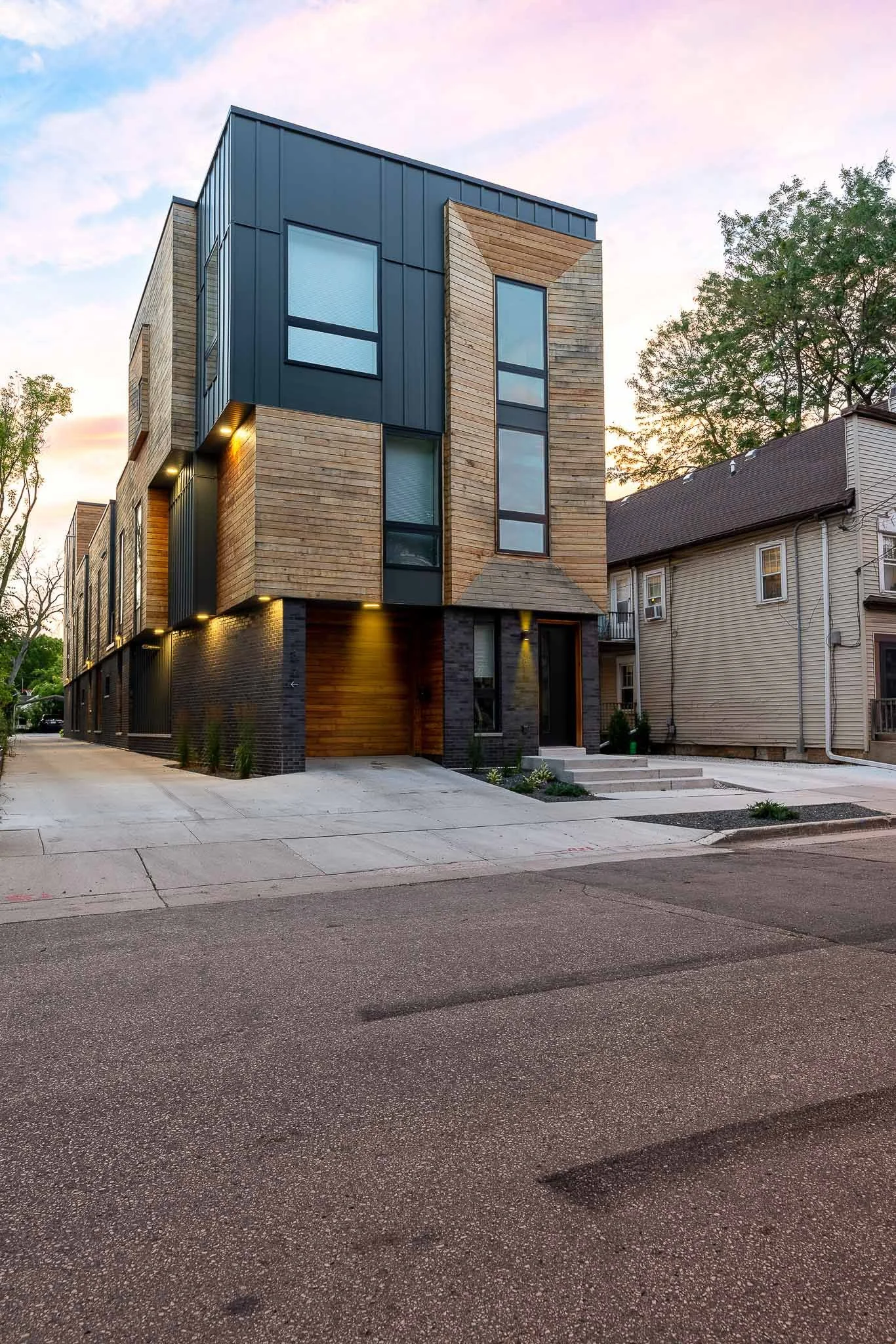 Contemporary dark-clad residential townhomes illuminated against a deep blue evening sky — Milwaukee modern residential architecture photography
